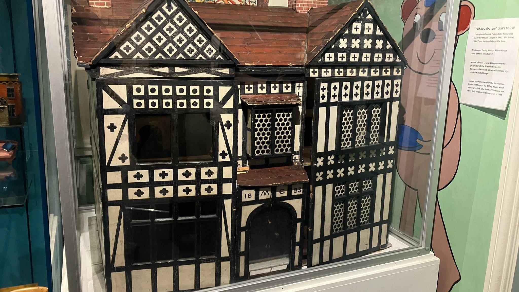 A dolls house in tudor style decor on display at Abbey House Museum