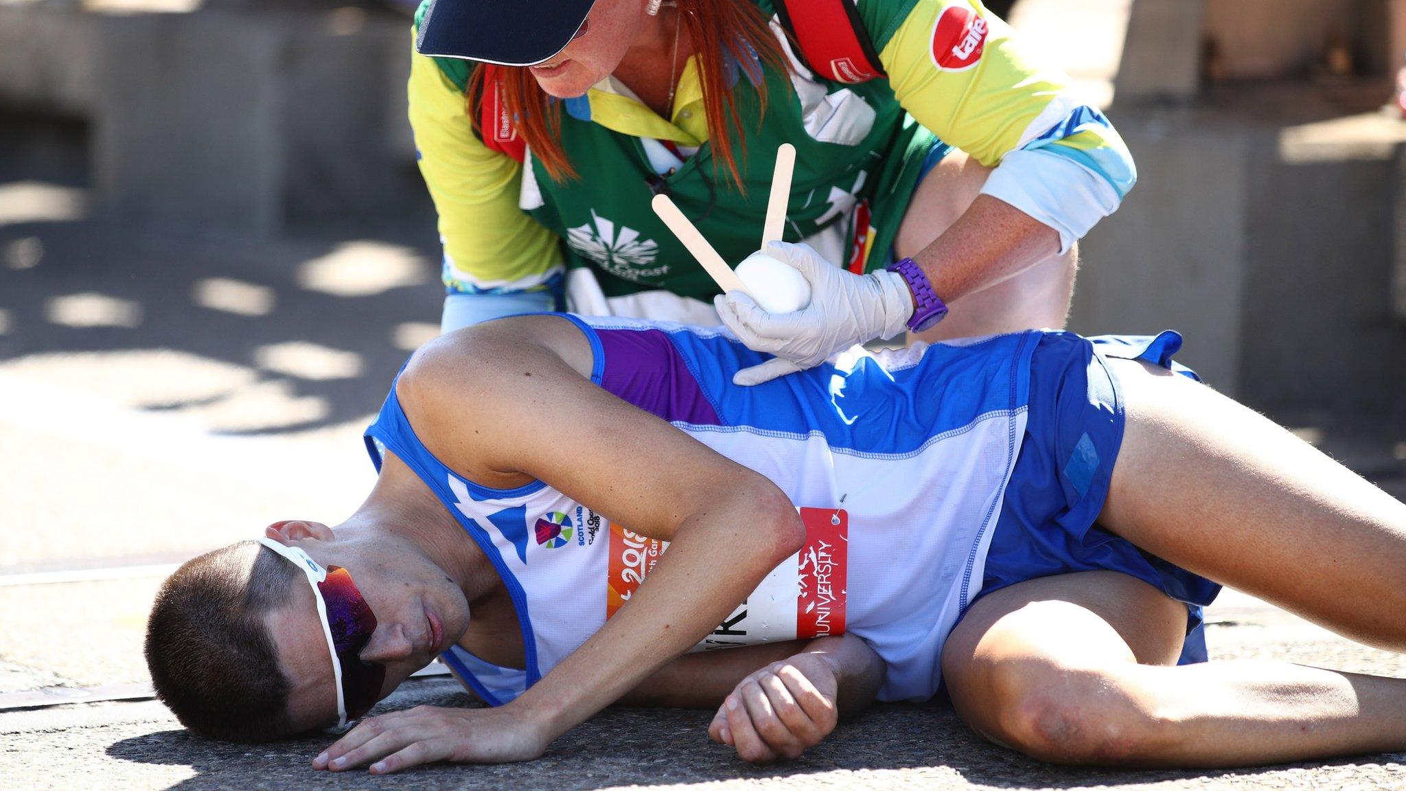 Callum Hawkins receiving medical attention after collapsing during the marathon