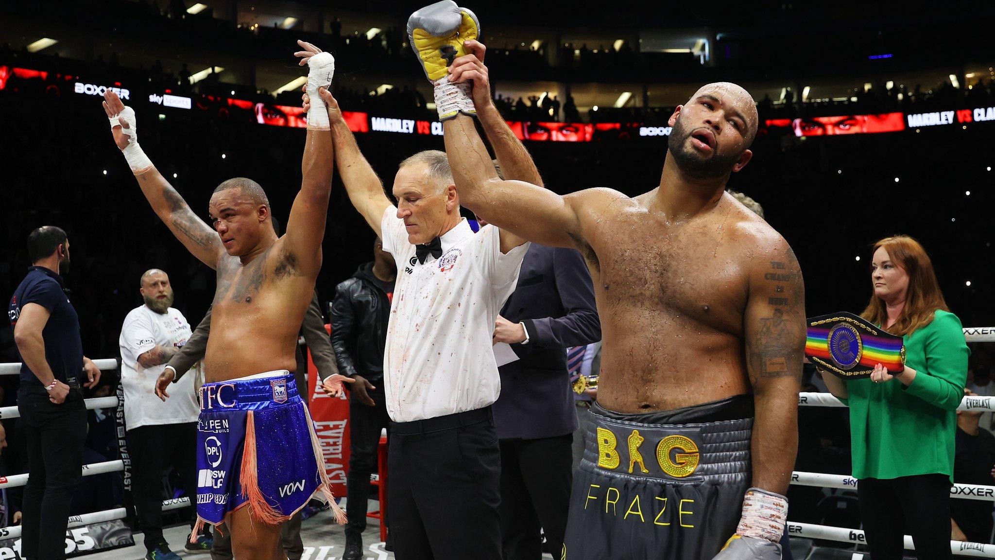 The referee raises the hand of Fabio Wardley (L) and Frazer Clarke in the ring