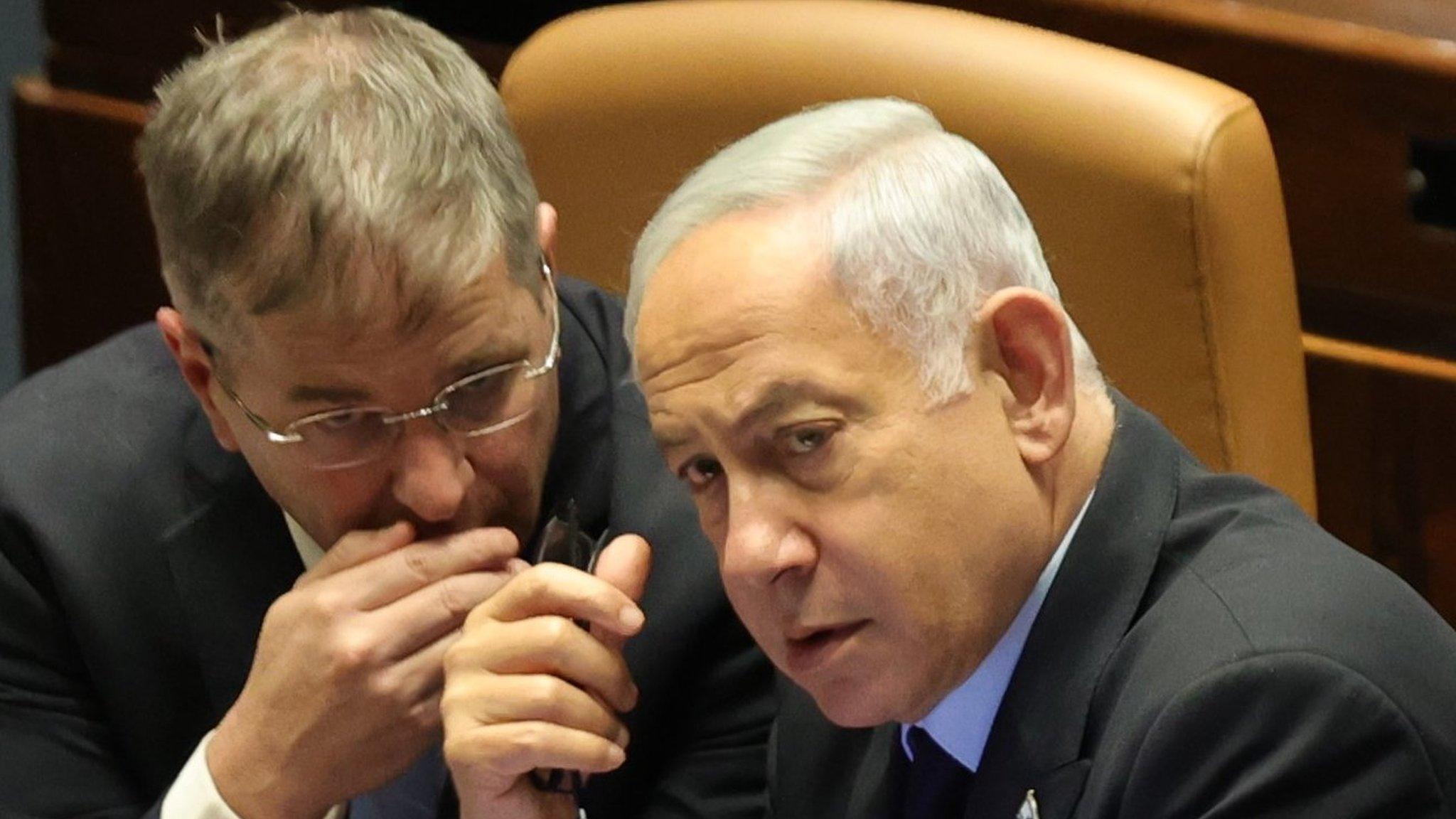 Israeli Prime Minister Benjamin Netanyahu (R) attends a voting session in the Knesset on 22 March 2023