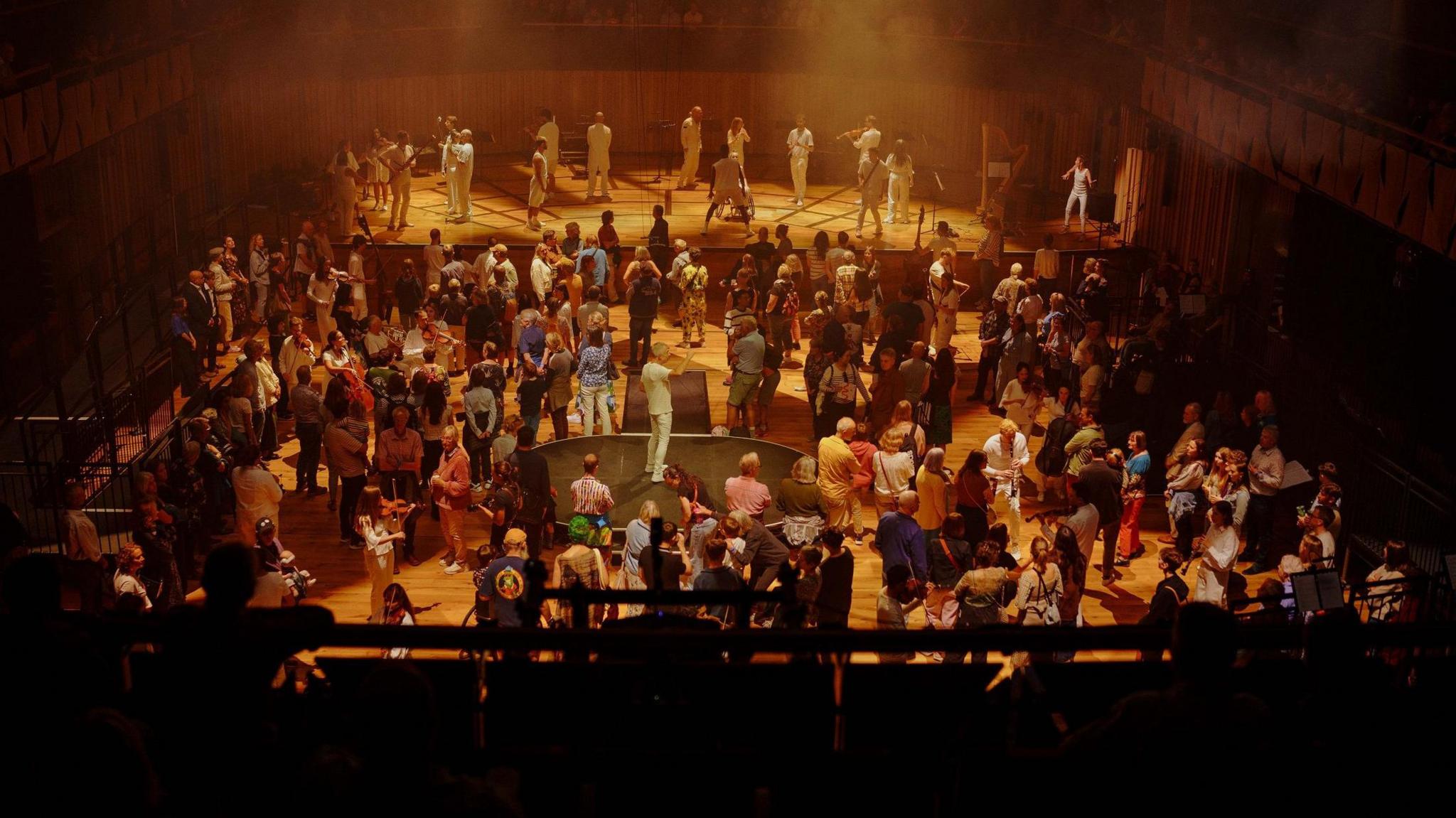 A crowd of people mingling with various musicians in the concert hall