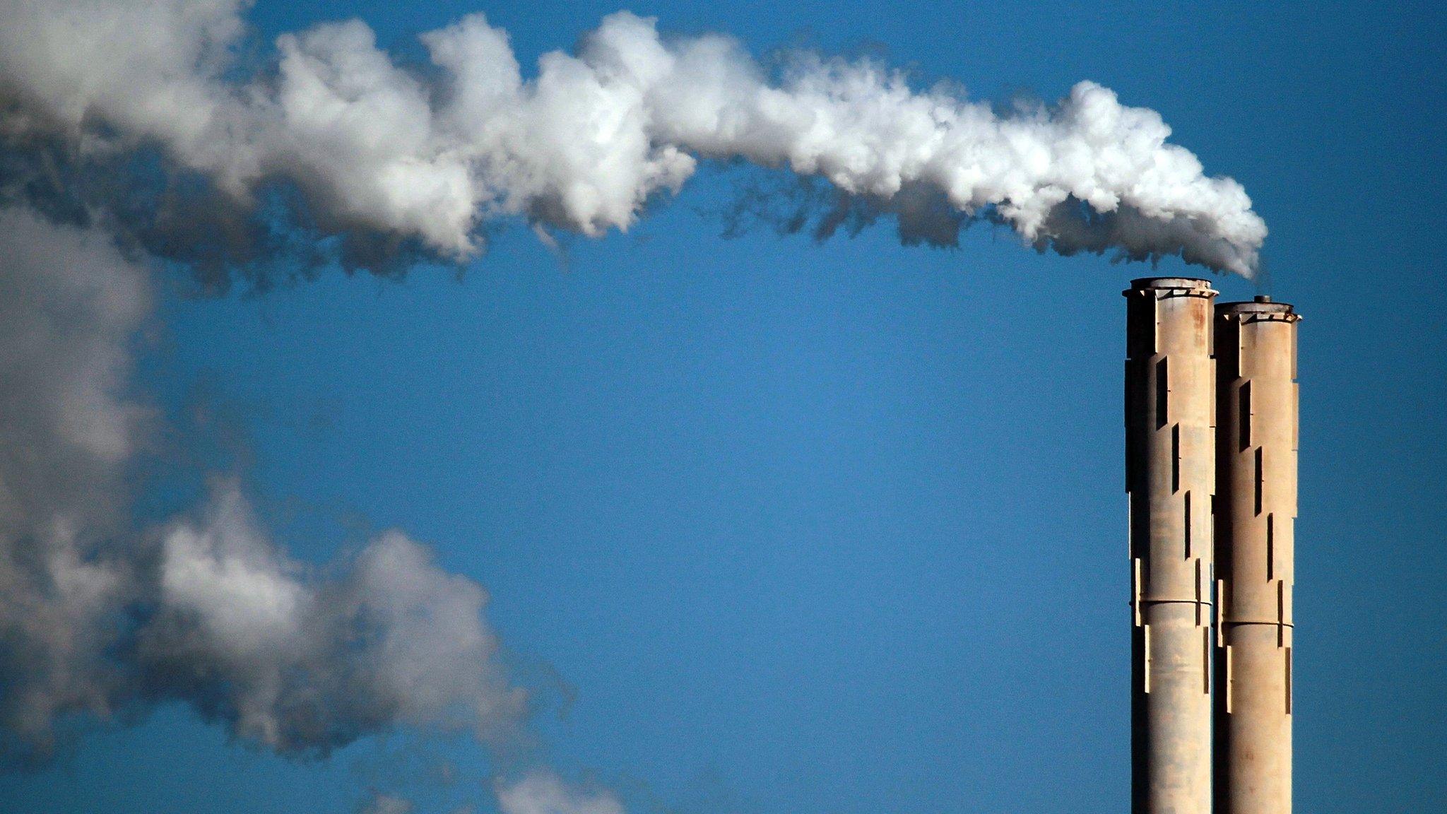 Steam rises from an oil refinery in the US