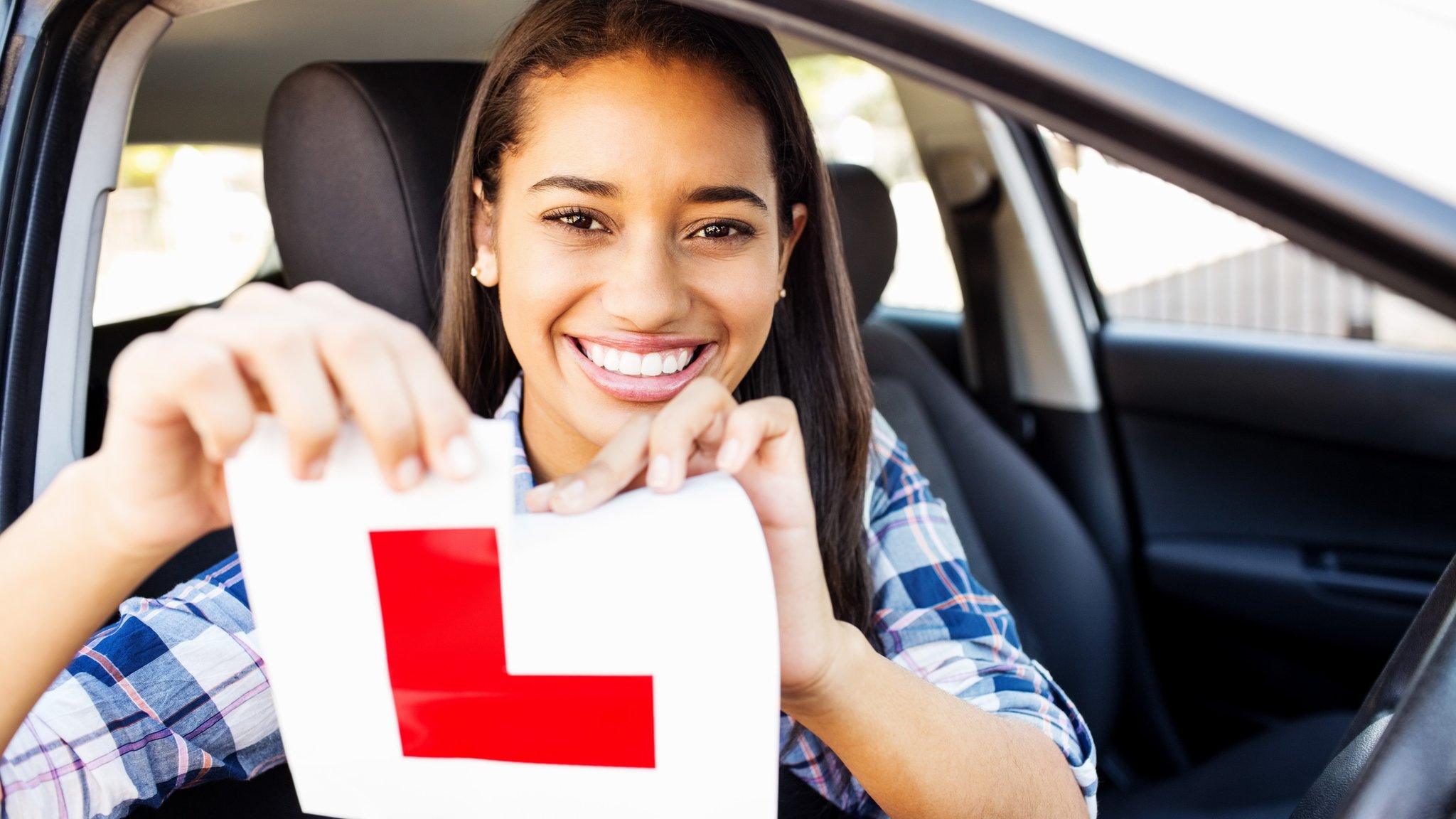 Photo of a woman tearing up a learners sticker