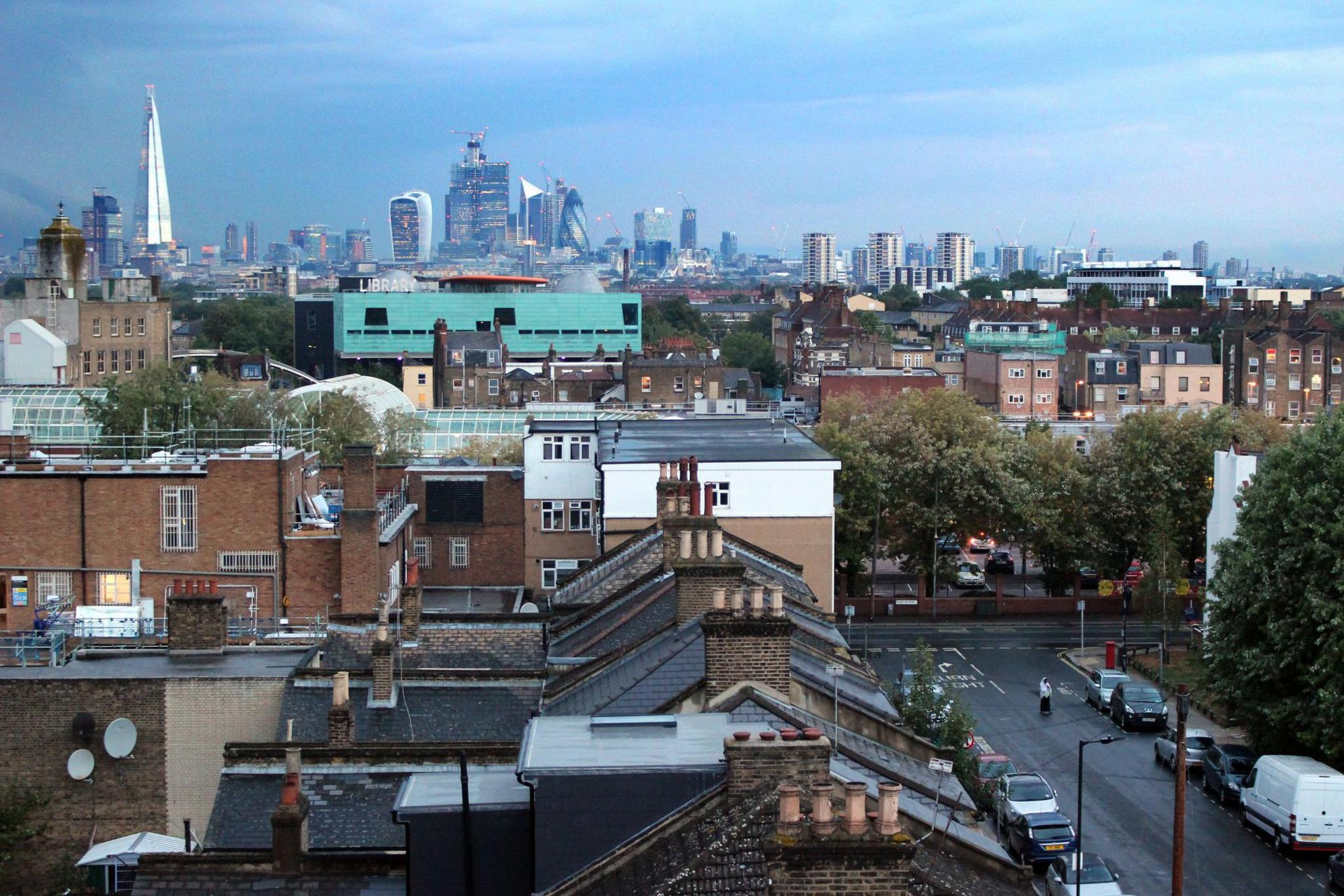 View of the centre of London, England, UK, at dusk as seen from Peckham. Skyscrapers from the London skyline can be seen in the distance, namely the Shard and the walkie-talkie (20 Fenchurch)