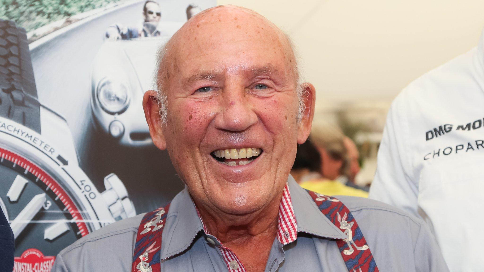 Sir Stirling Moss smiles at a motor racing event