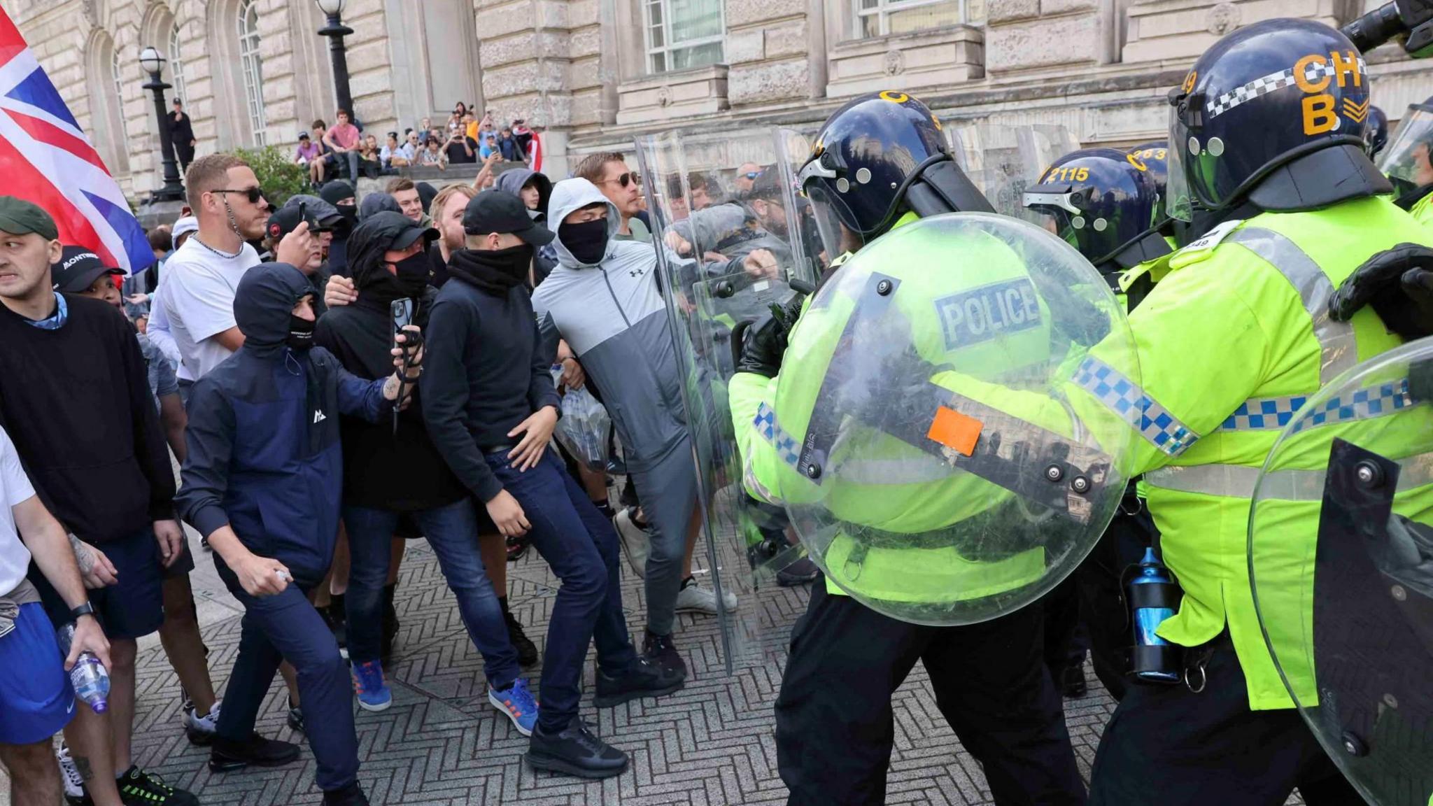 Police officers and demonstrators clash during a protest against illegal immigration, in Liverpool,