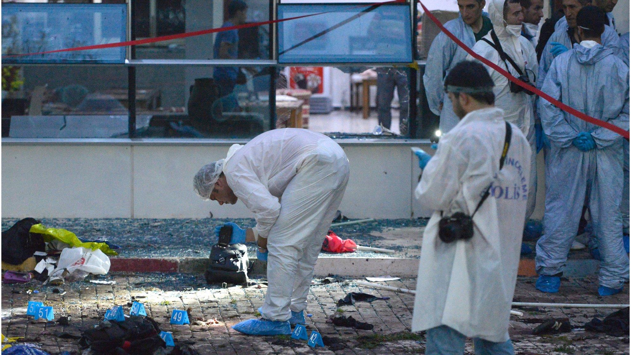 Turkish police officers search the area after a explosion in Suruc, Sanliurfa province, Turkey (20 July 2015)