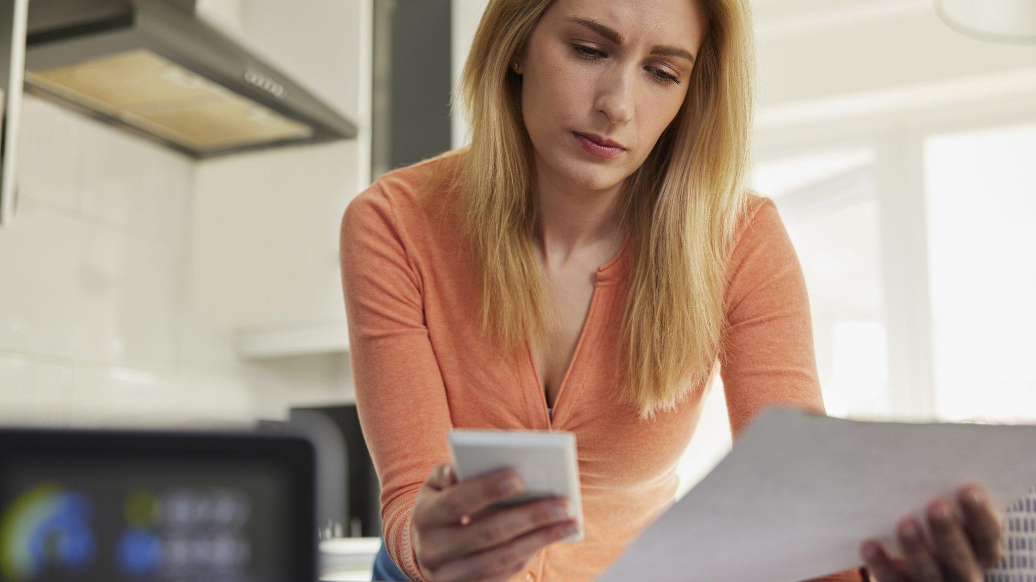 Woman looking at bills with calculator