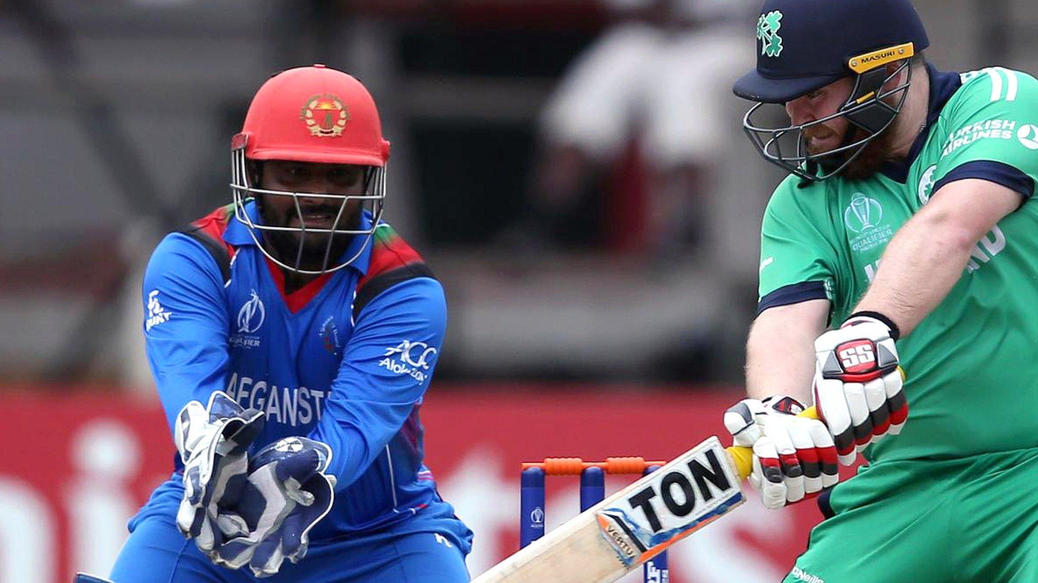 Afghanistan wicketkeeper Mohammad Shahzad closes in as Paul Stirling plays a shot