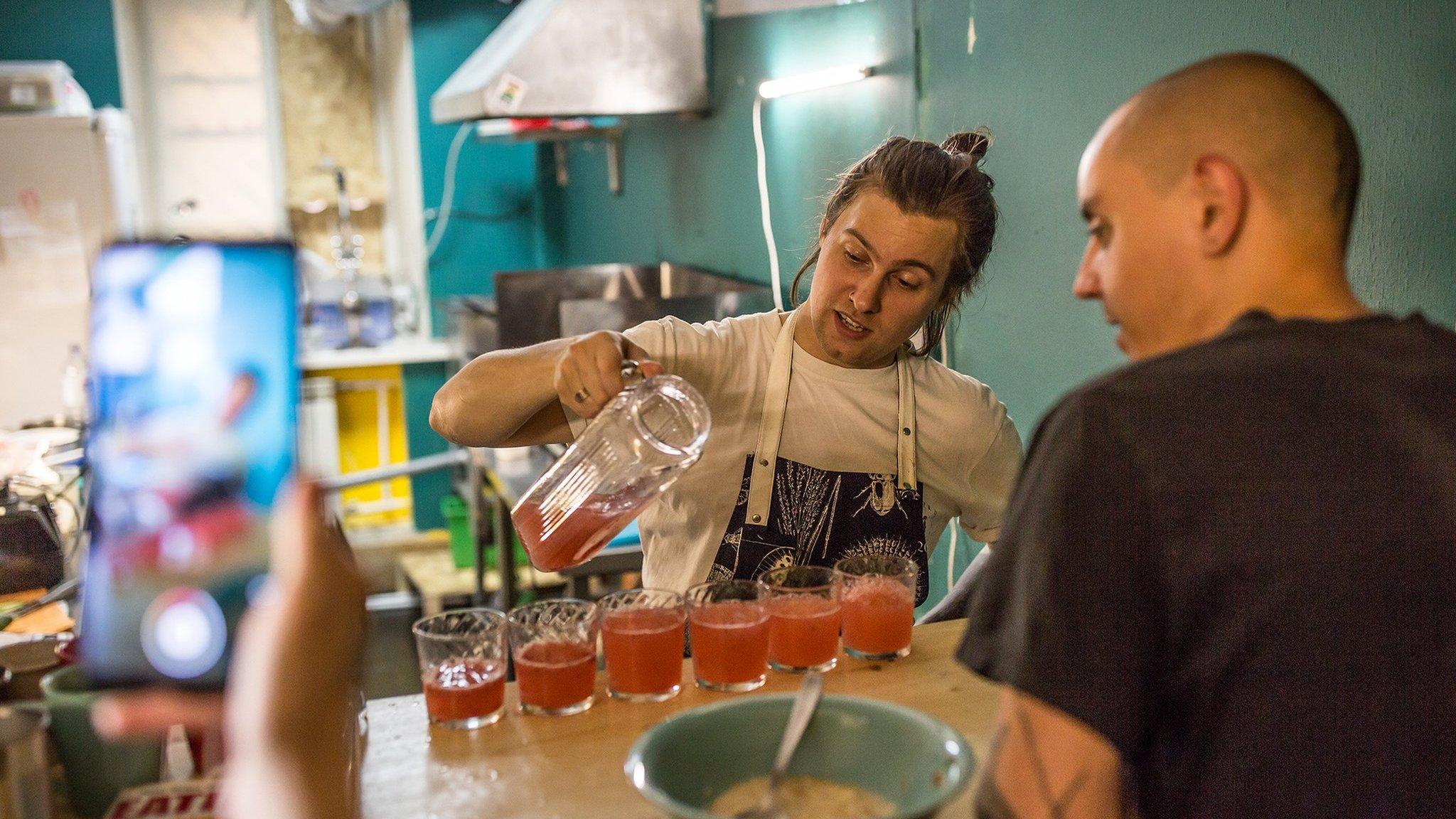 Iiura serving drinks at the opening of his restaurant, Tempeh Time