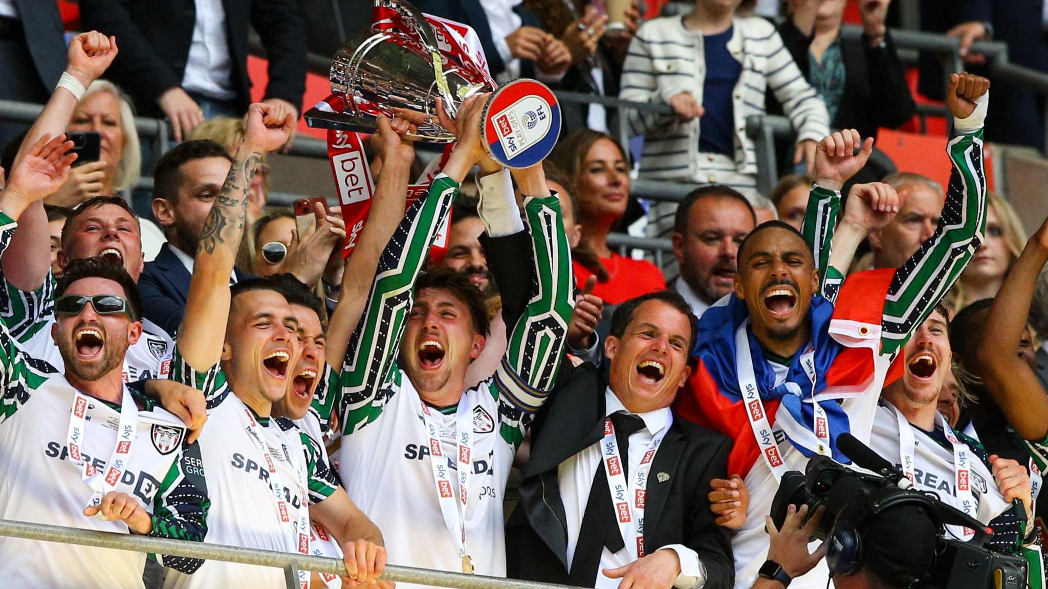 Sunderland players celebrate by lifting the Championship play-off final trophy at Wembley in May 2025