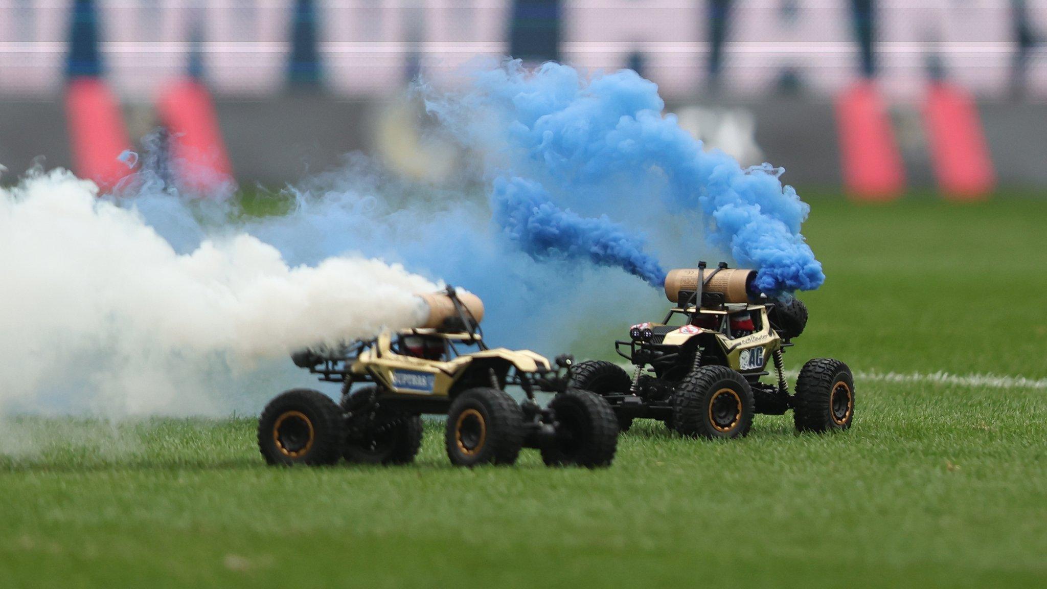 Two remote control cards with smoke bombs attached on the pitch