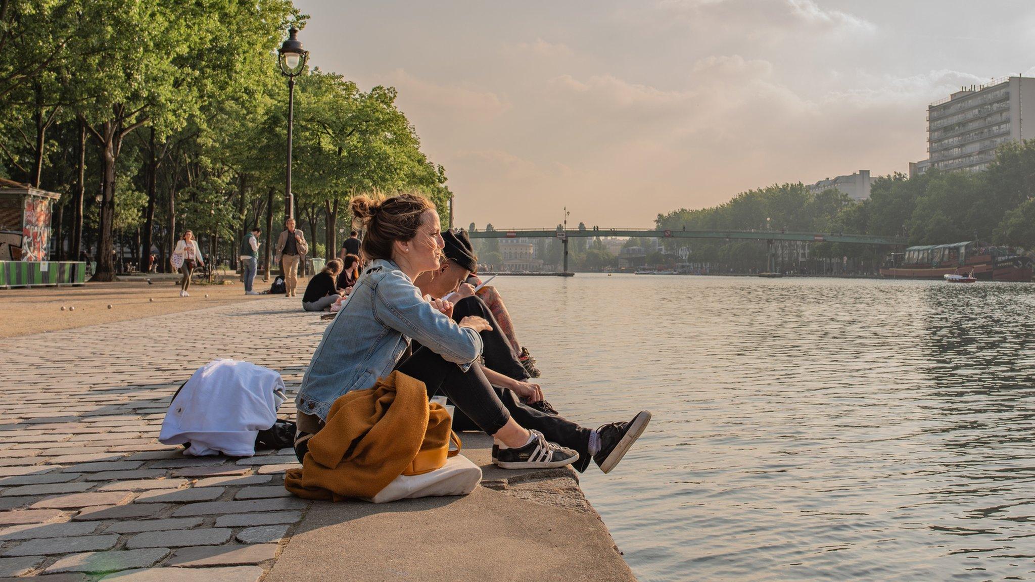 Women sitting by the canal in Paris