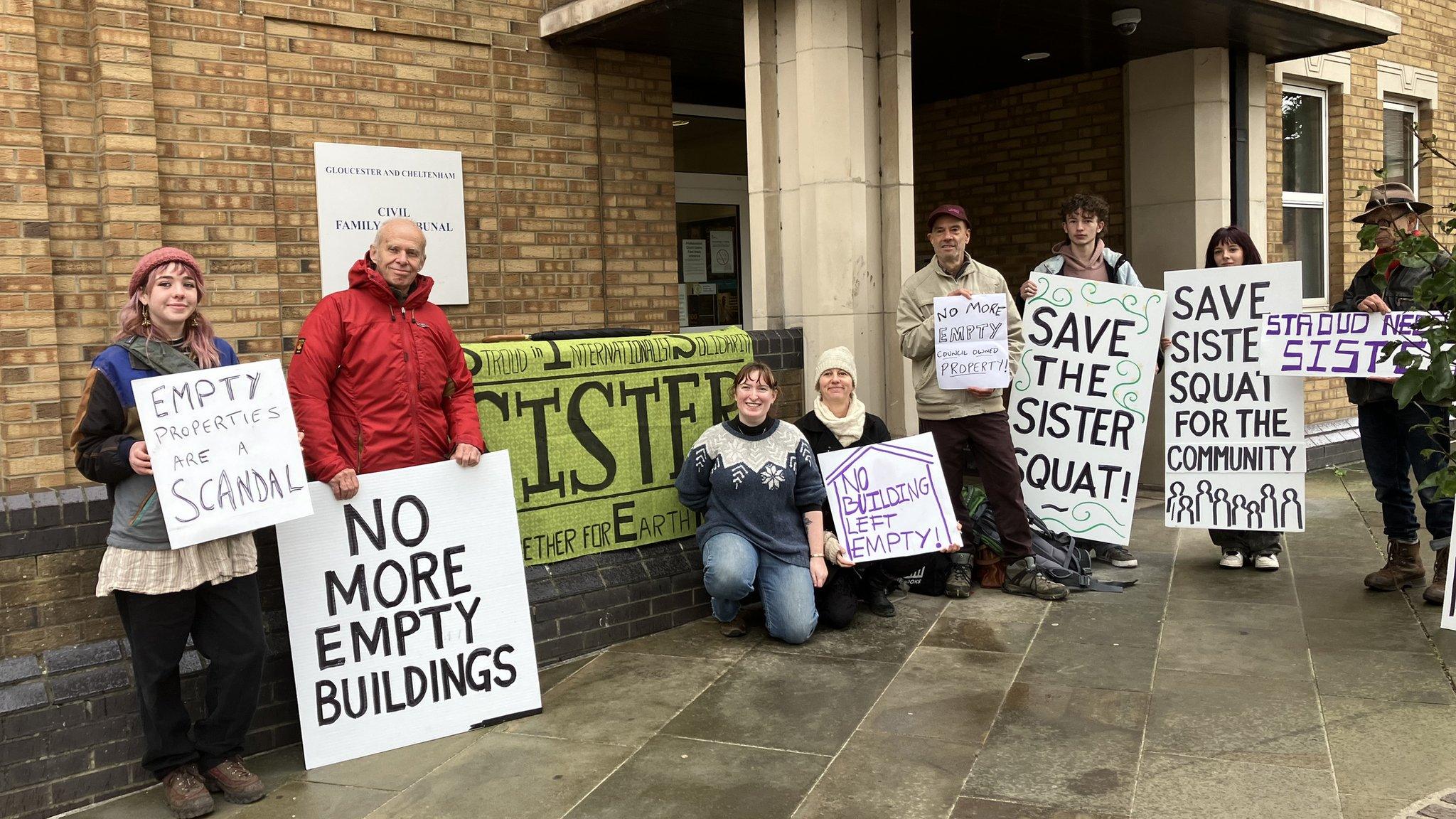 campaigners outside Gloucestershire County Court with placards.