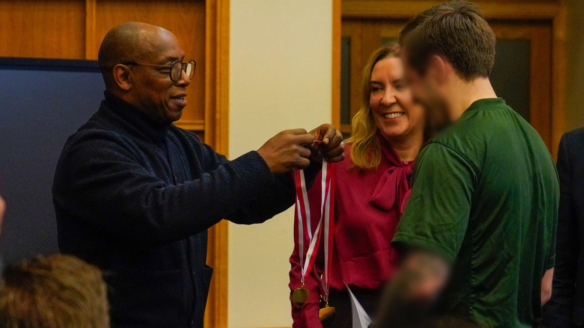 Former Arsenal and England striker Ian Wright gives out a medal at a football coaching session at North London's HMP Pentonville