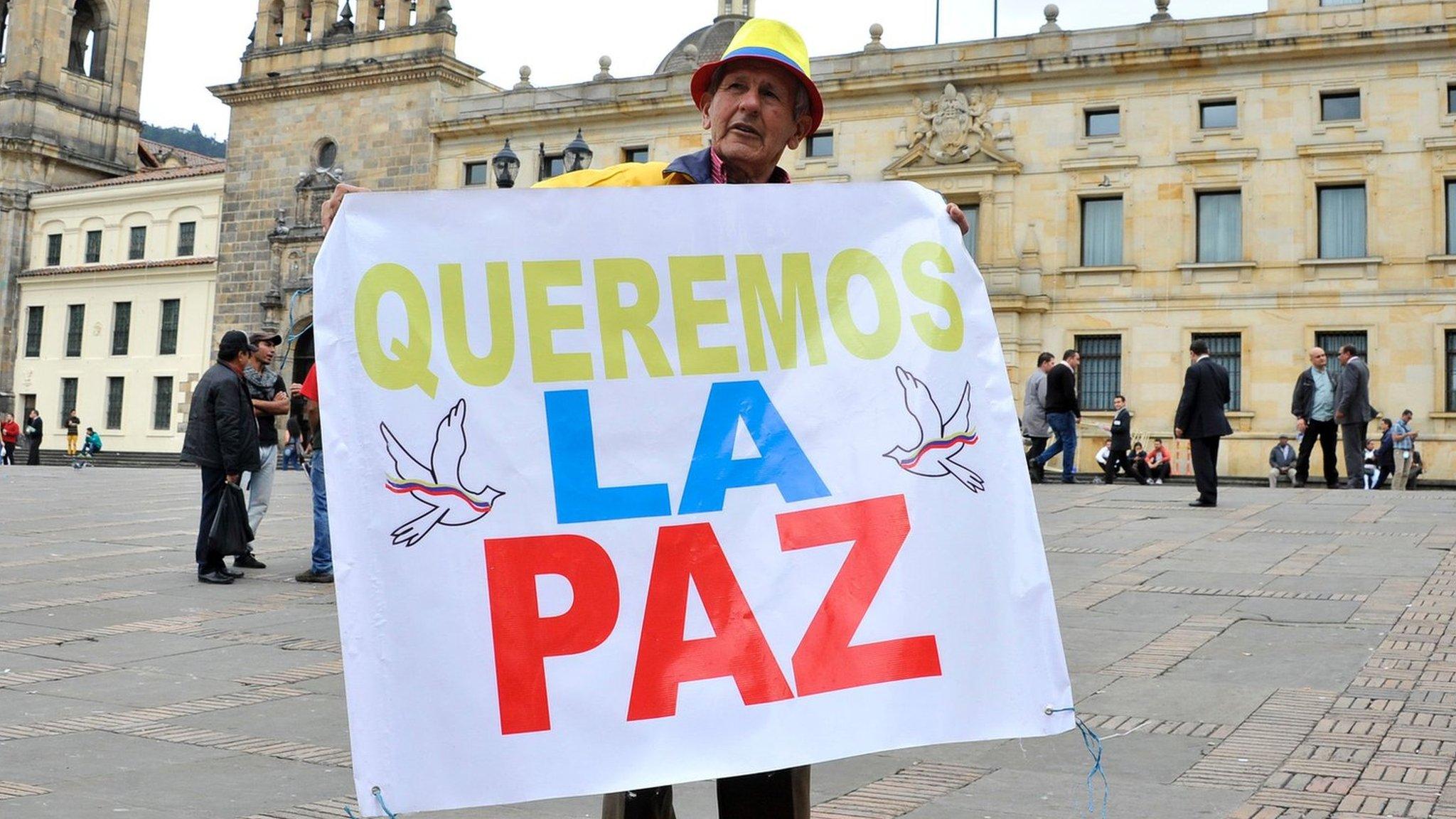 Man holds a sign reading "We want peace" outside the Colombian Senate in Bogota, on November 29, 2016