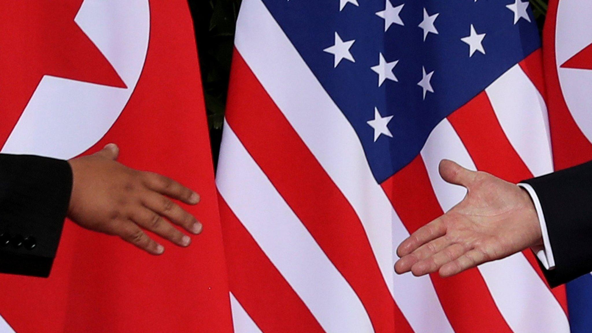 Donald Trump shakes hands with Kim Jong-un