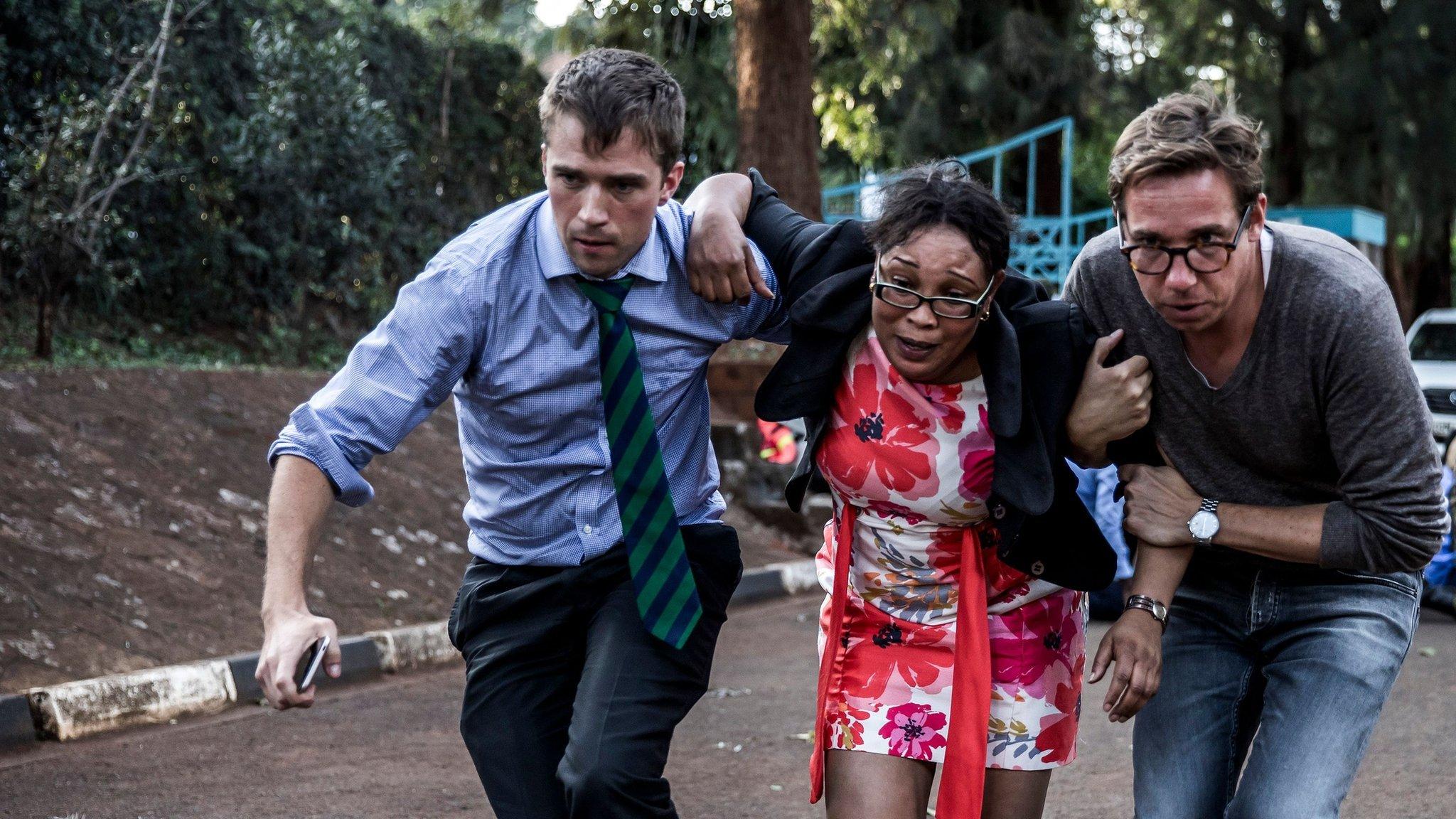 A woman is evacuated from the scene of an explosion at a hotel complex in Nairobi's Westlands suburb on January 15, 2019,