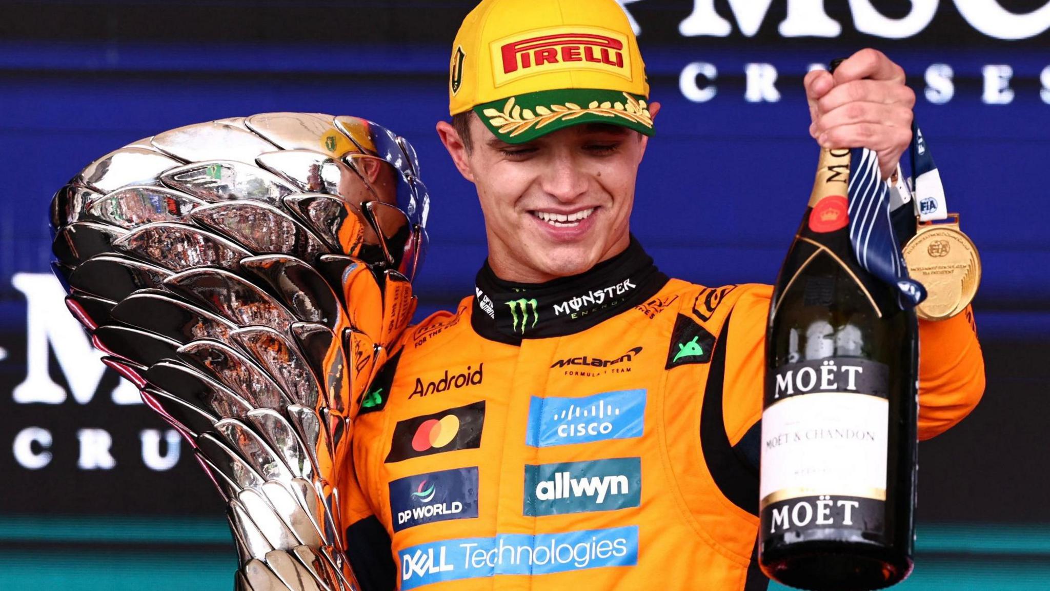 Lando Norris holds the winner's trophy and a bottle of champagne after winning the Sao Paulo Grand Prix