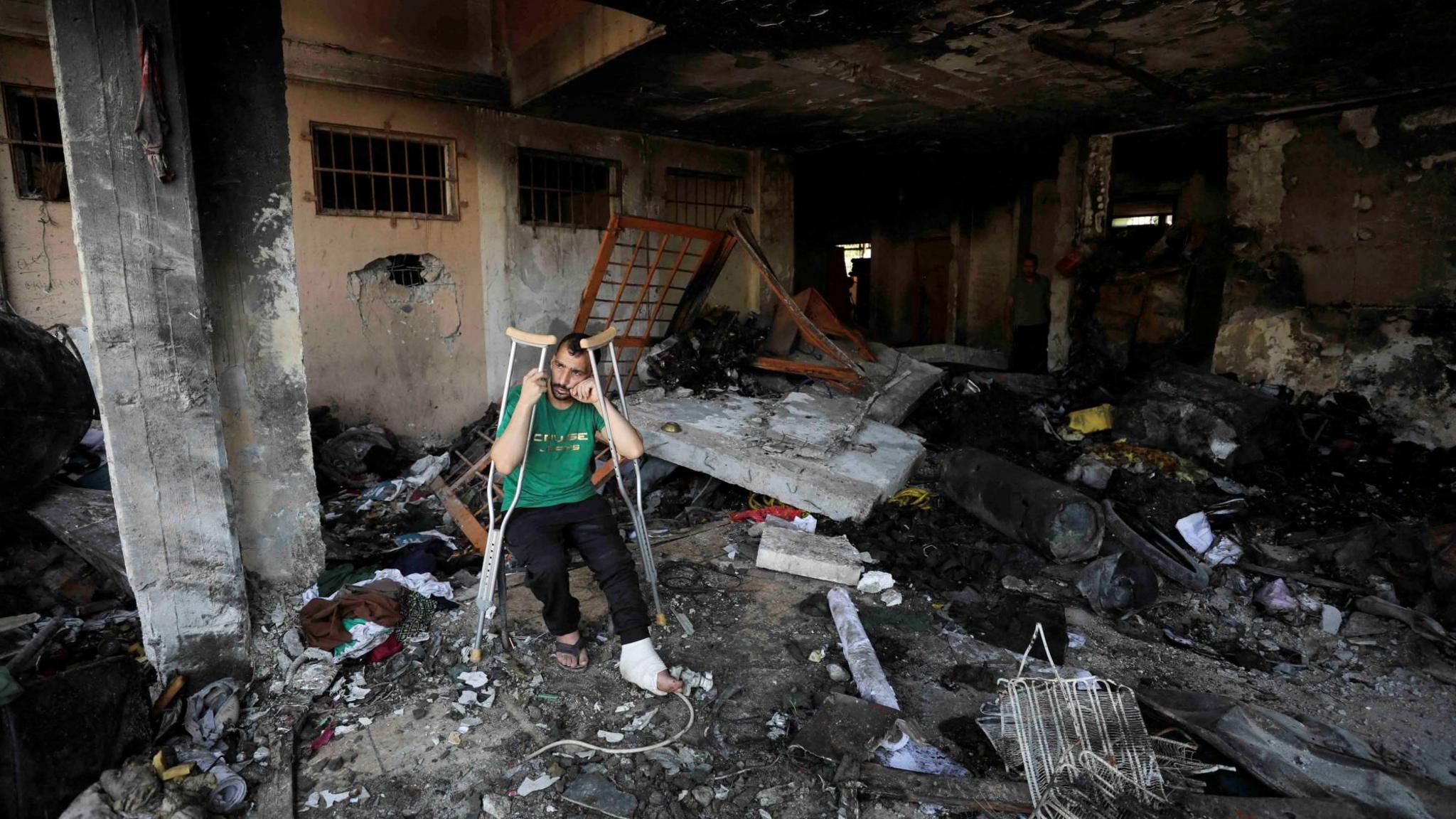 An injured man sits inside Abdulfattah Hamoud school in Gaza City after it was damaged in an Israeli air strike (25 June 2024)