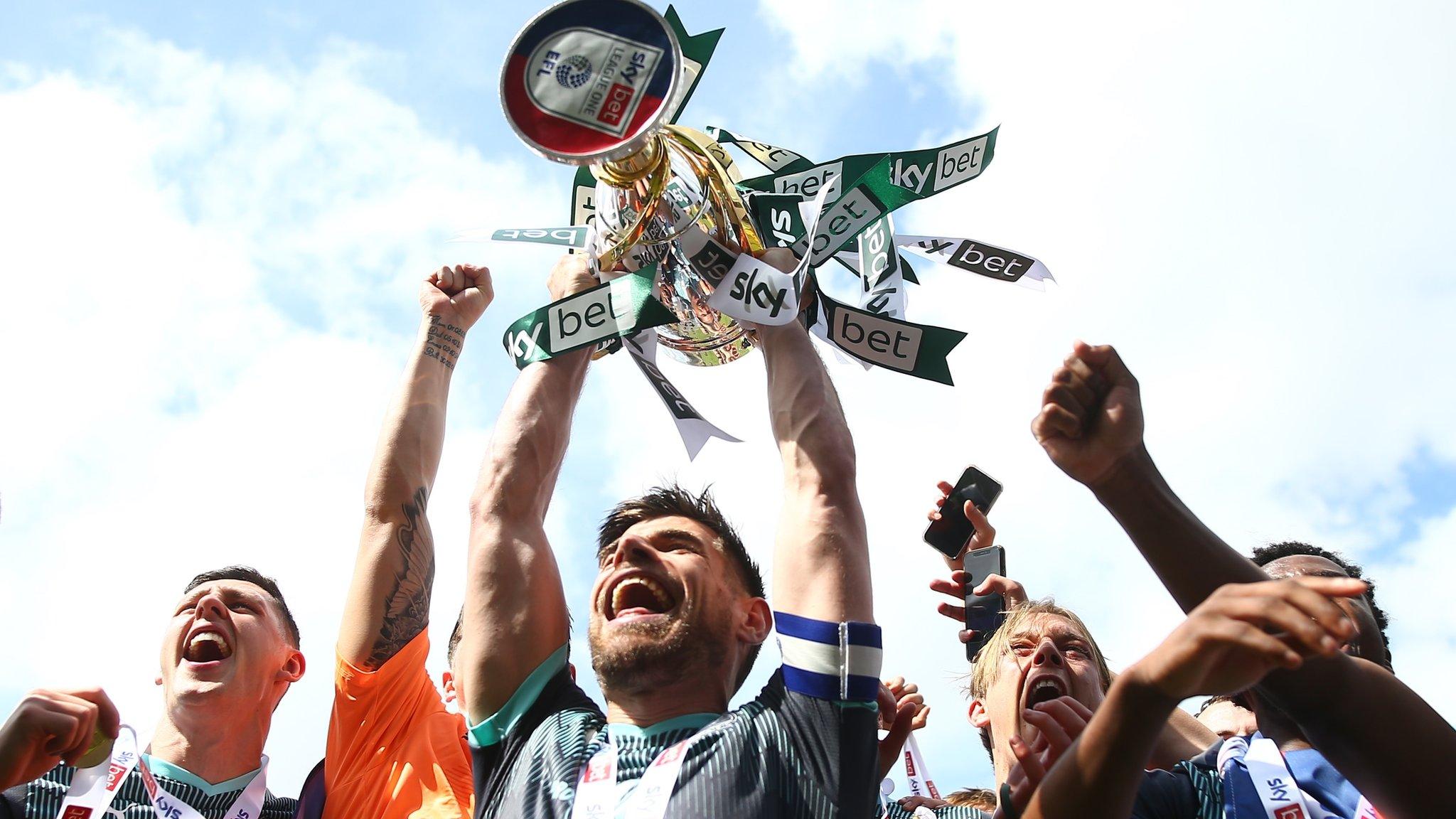 Joe Edwards lifts the League One trophy