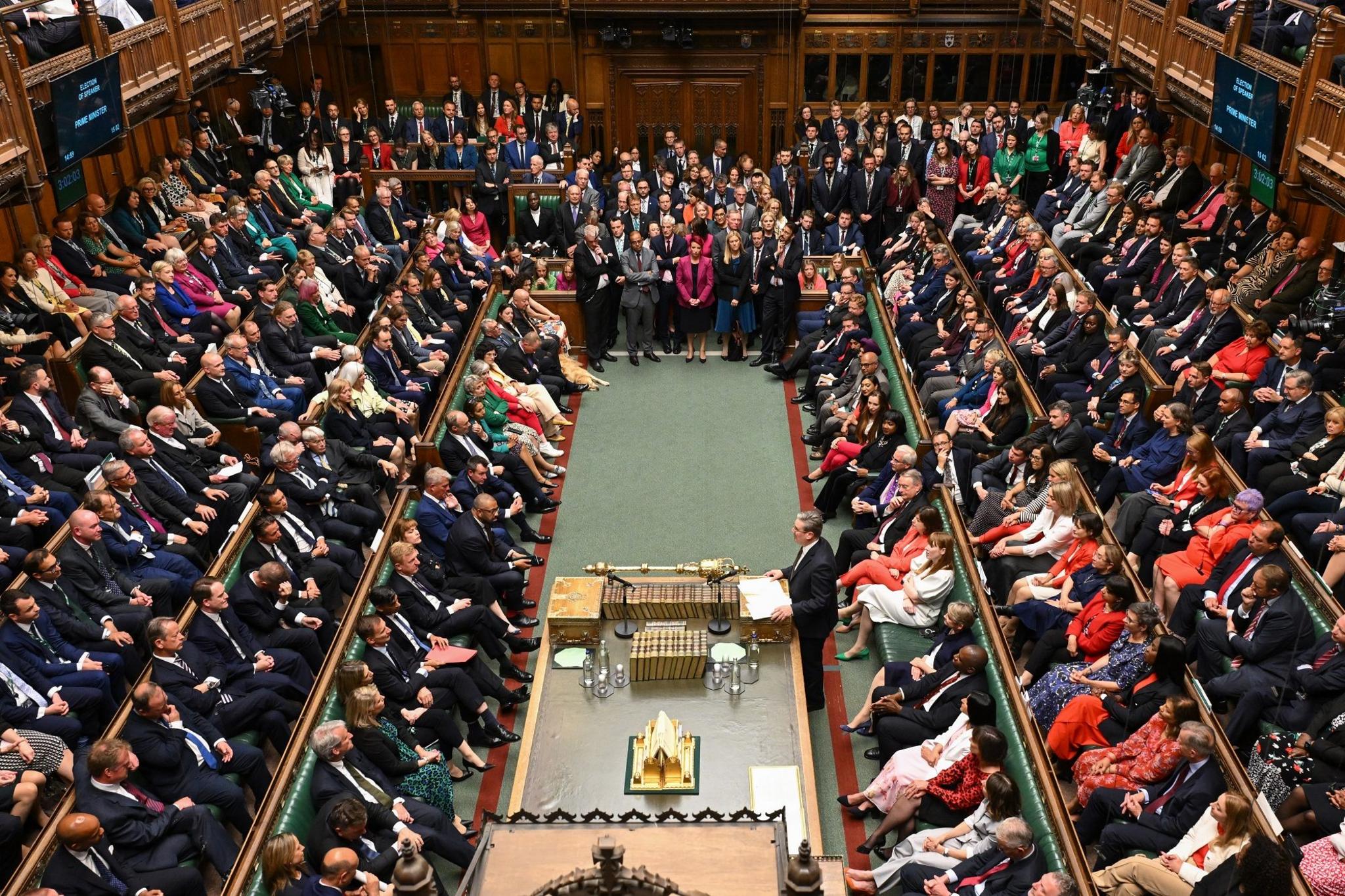 A packed House of Commons chamber, with many MPs standing