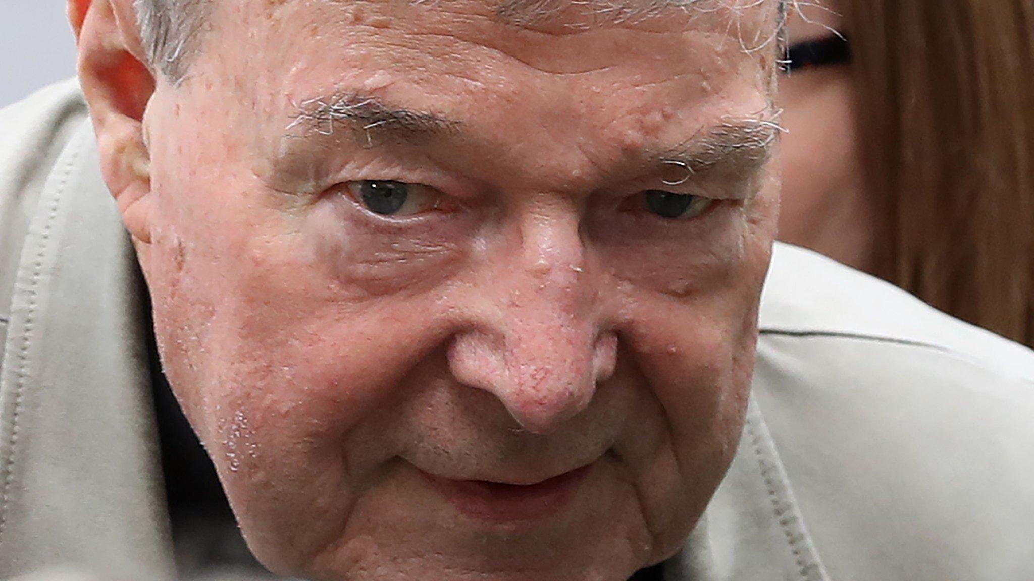 Cardinal George Pell walks from a car in Melbourne