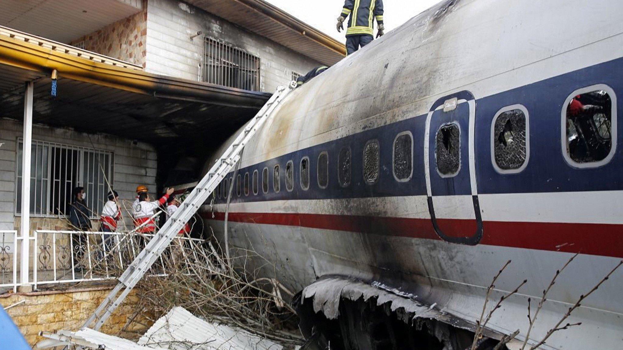 Emergency services personnel work at the scene of a plane crash in Alborz province, Iran (14 January 2019)