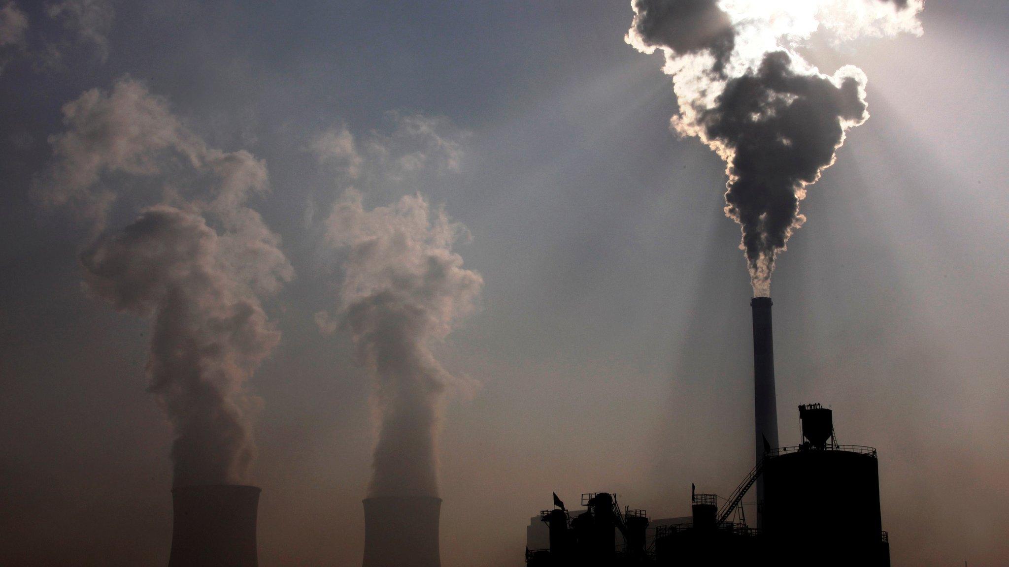 A coal-burning power plant can be seen behind a factory in the city of Baotou, in China's Inner Mongolia Autonomous Region, 31 October, 2010.