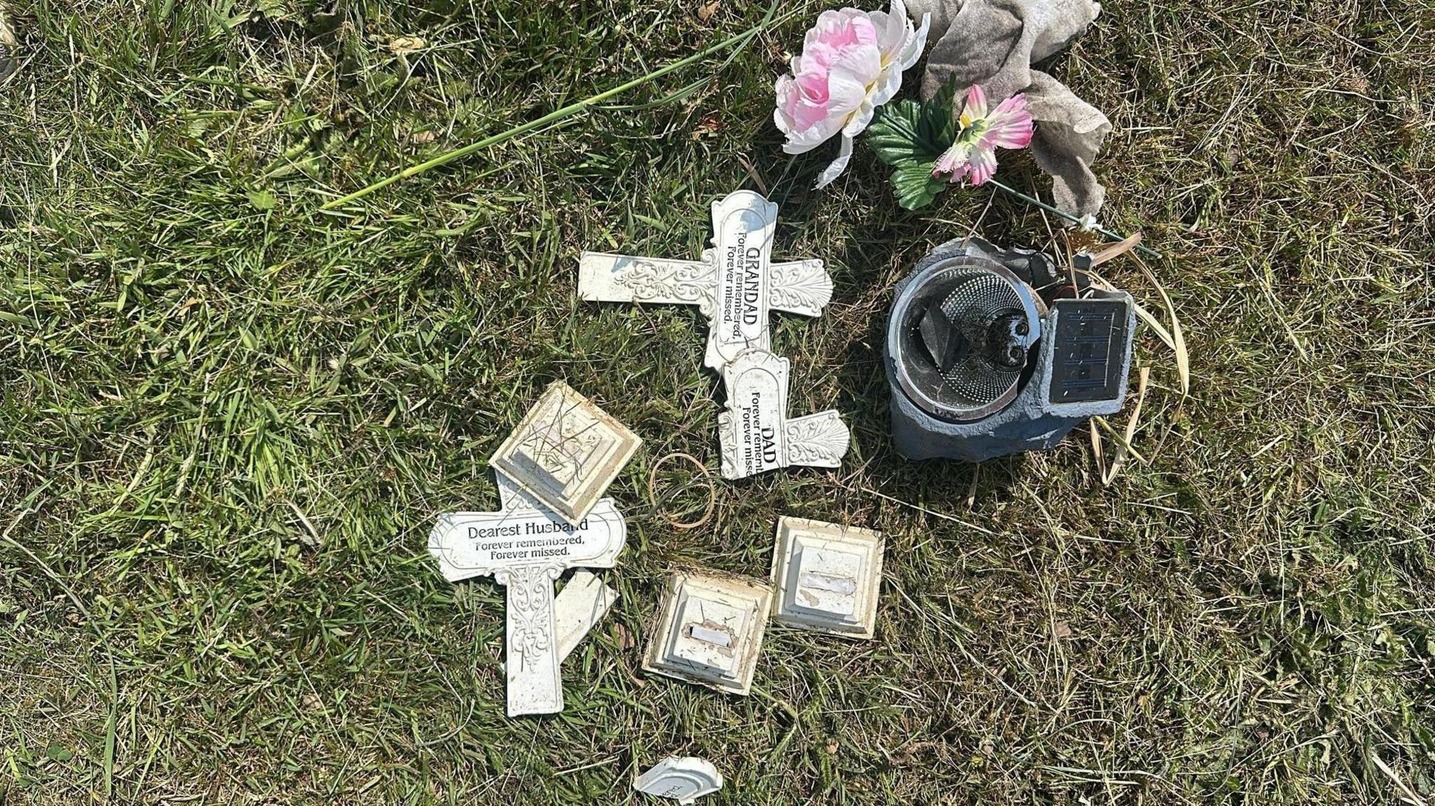 Broken ornamental crosses and an artificial flower holder