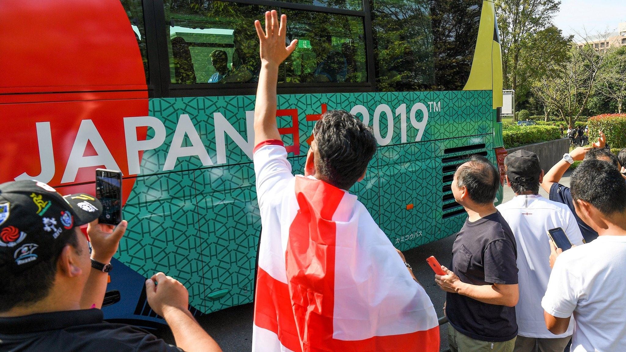 Fans in Japan wave at the England coach