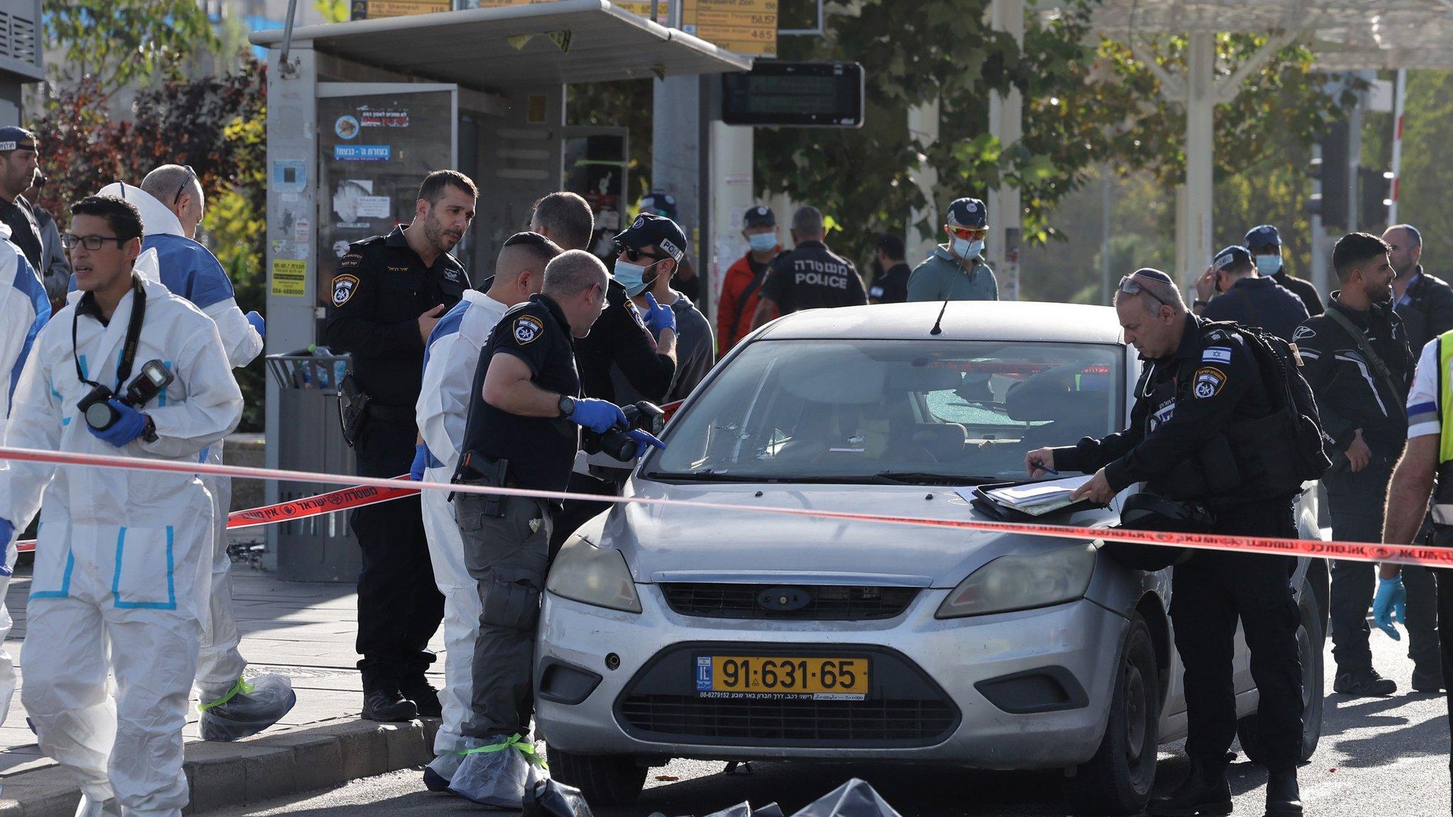 Israeli police inspect the scene of a deadly attack by Palestinian gunmen in West Jerusalem (30 November 2023)