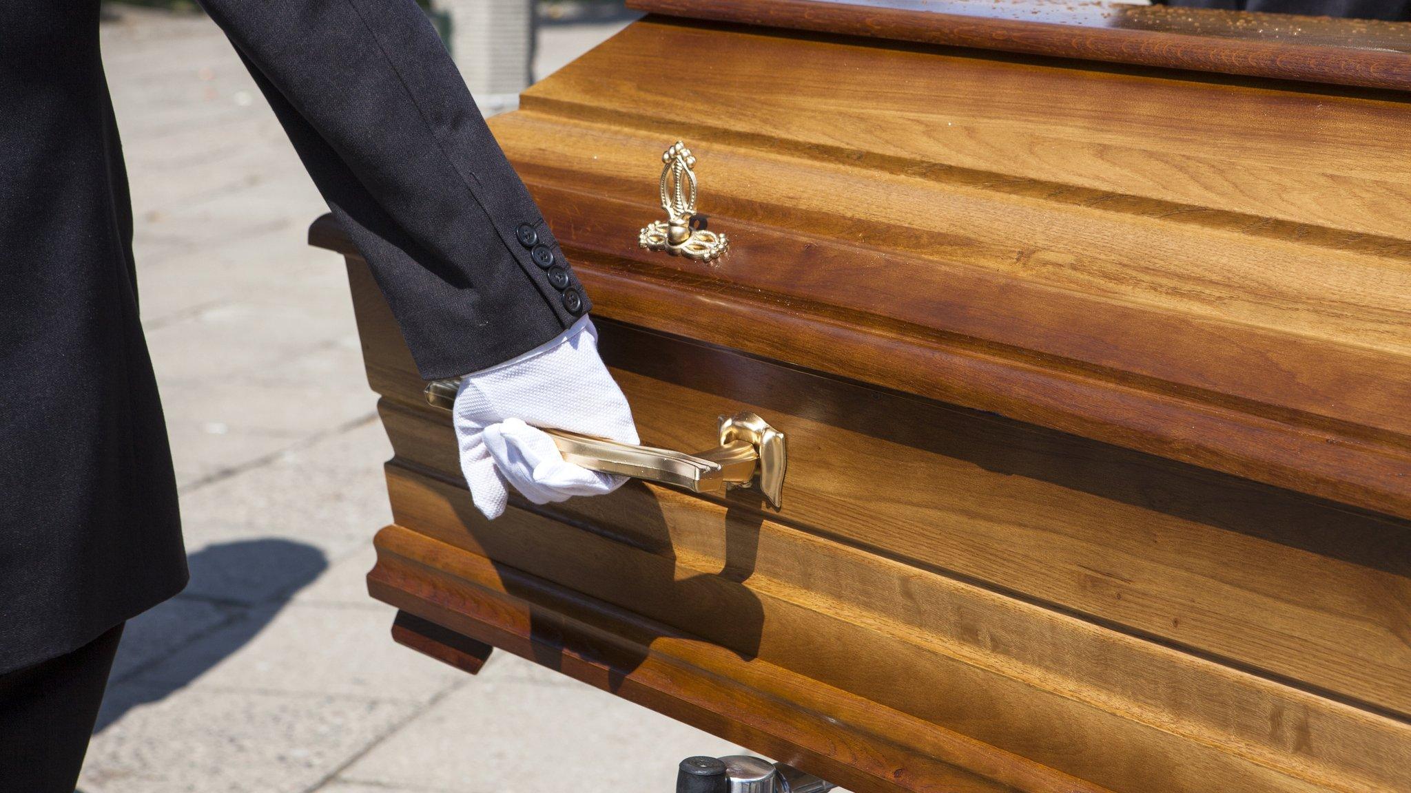 hand on coffin