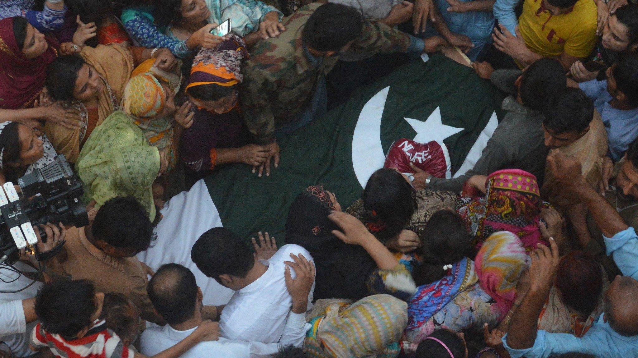 People surround the dead body of a Pakistani soldier allegedly killed by Indian firing, during a funeral in Faisalabad, Pakistan, Thursday, Sept. 29, 2016