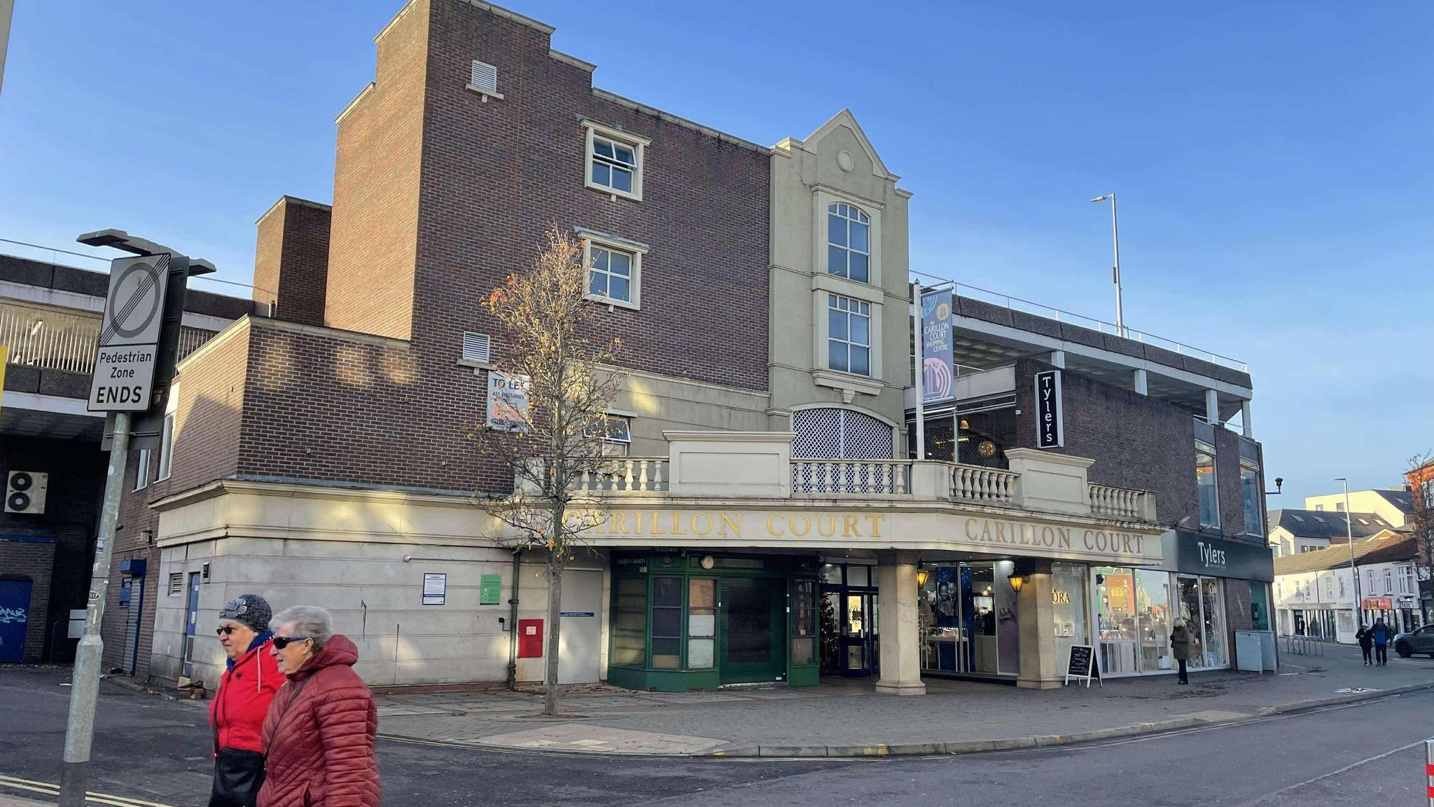 An entrance to the Carillon Court shopping centre from the rear, showing a glimpse of the car park on the roof too