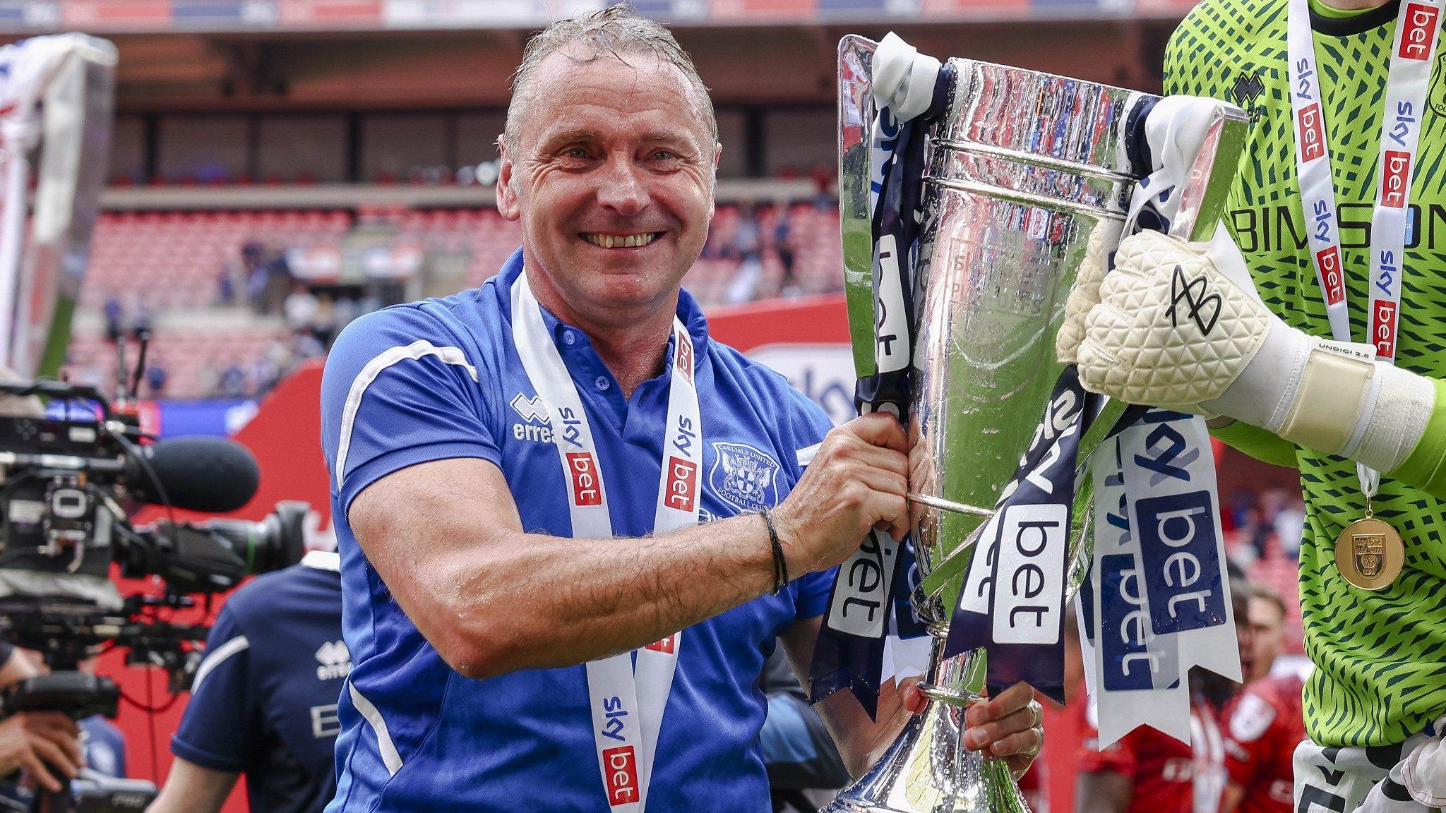 Paul Simpson with the play-off trophy