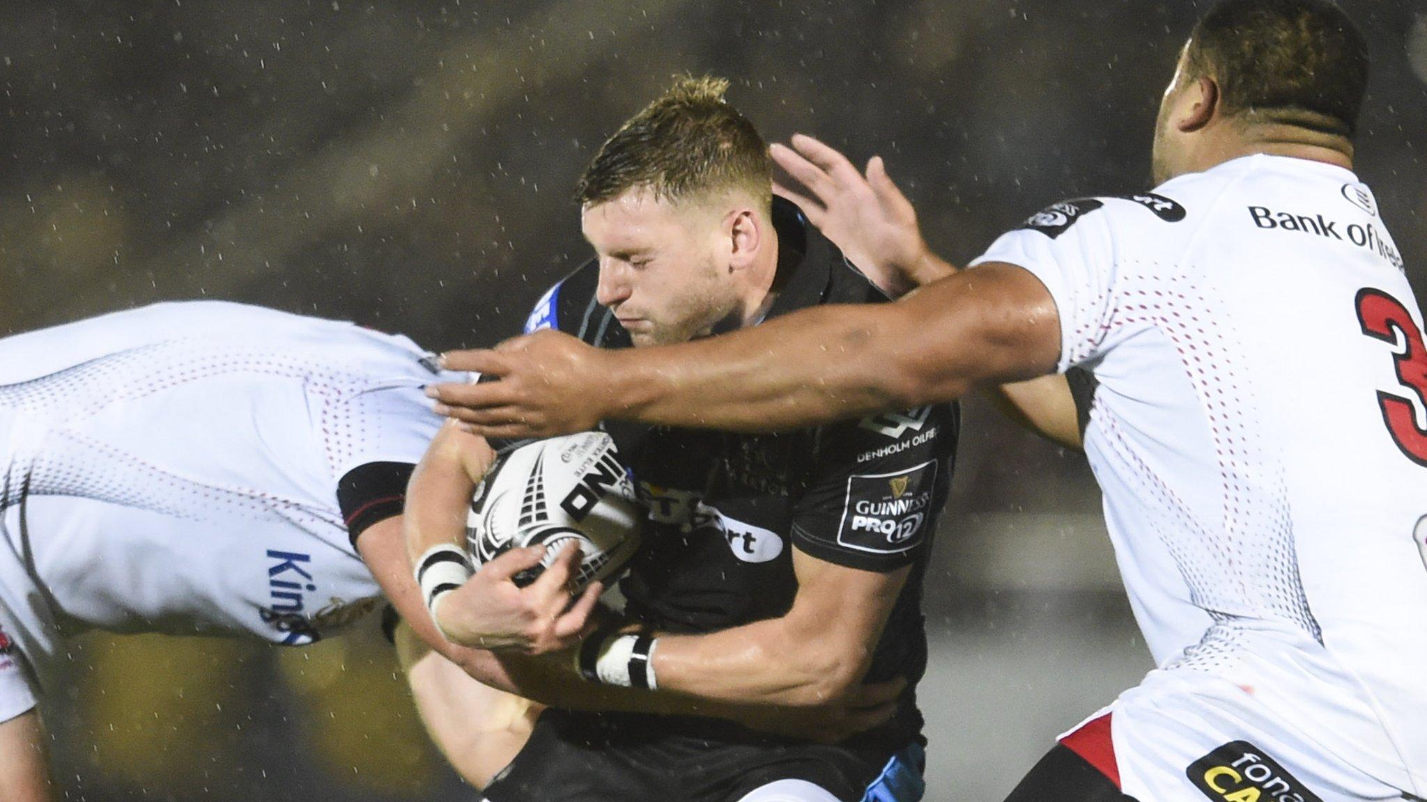 Glasgow fly-half Finn Russell is tackled by two Ulster players