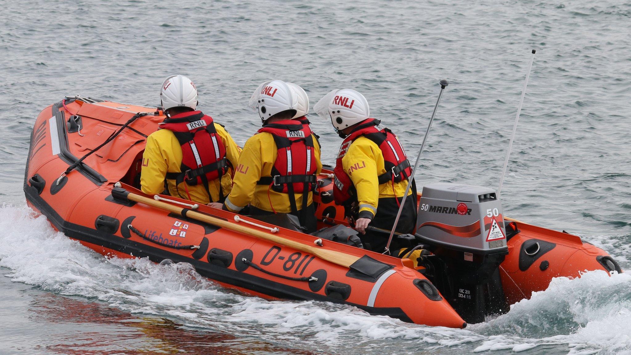 Criw RNLI ar y dwr yn Mhwllheli