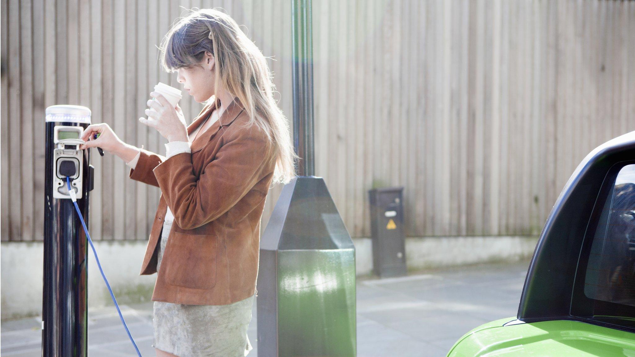 Woman charging electric car