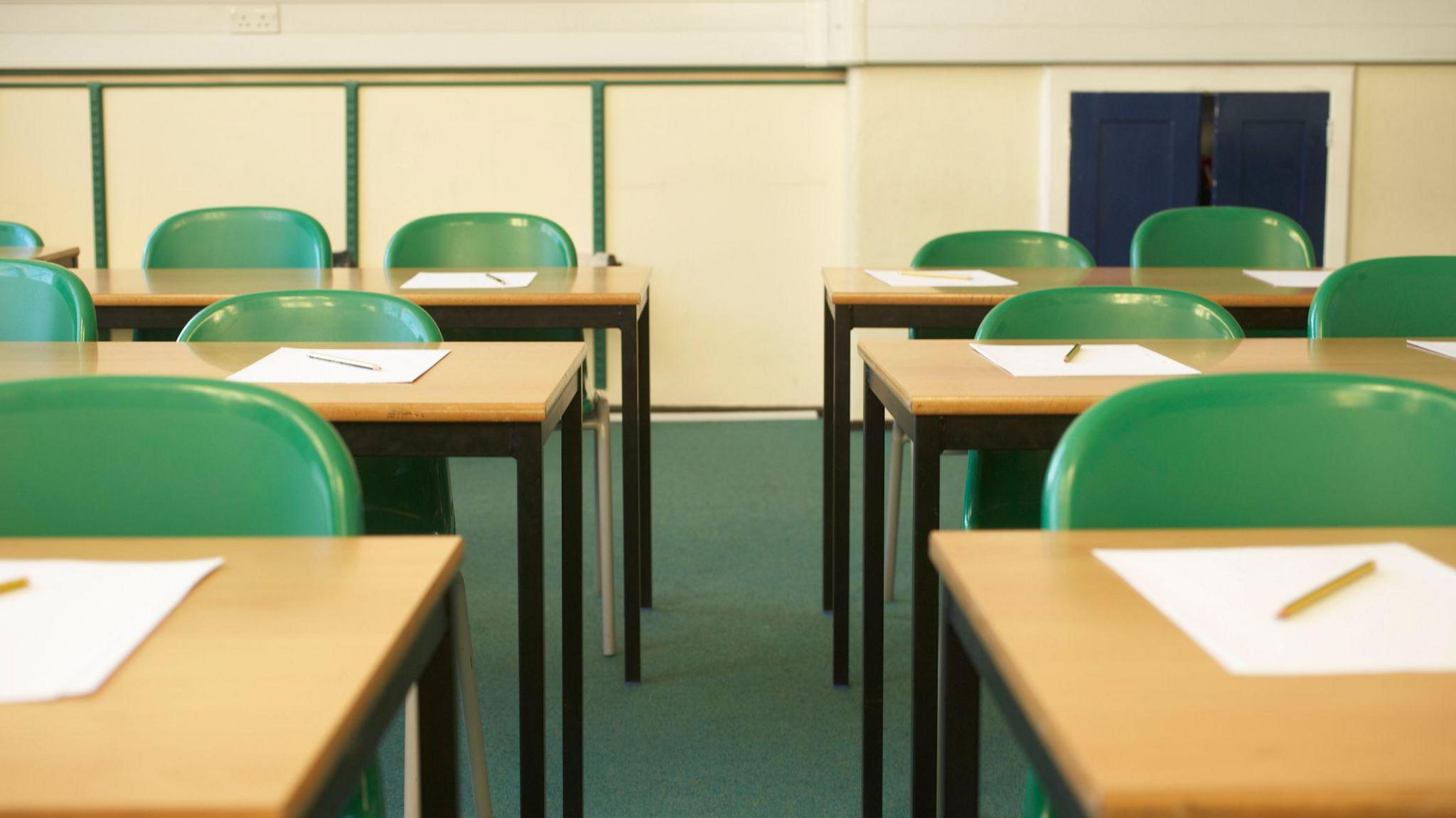 An empty classroom with green chairs 