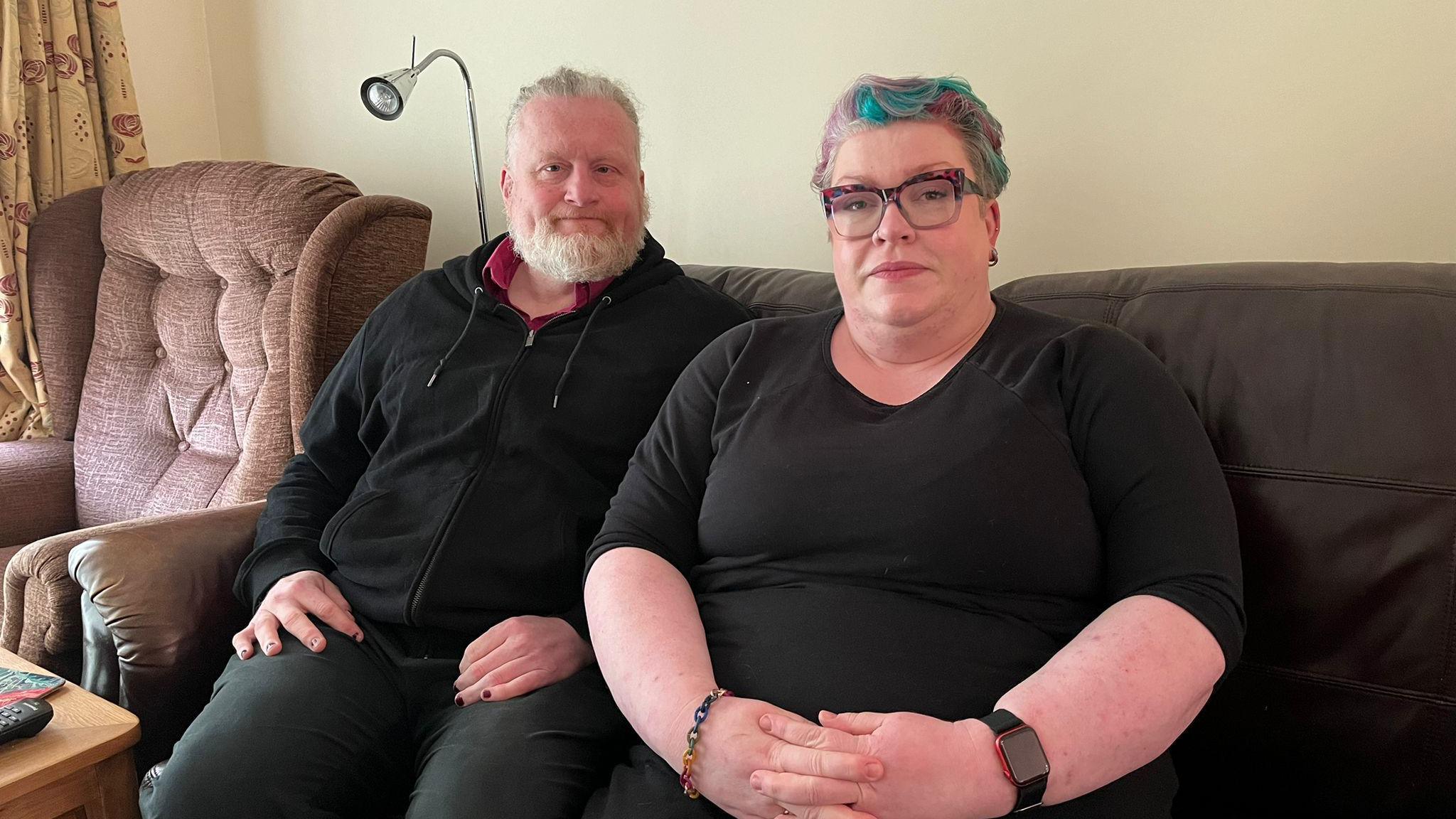 Dan and Hannah McKee sit on a sofa in Newcastle under Lyme