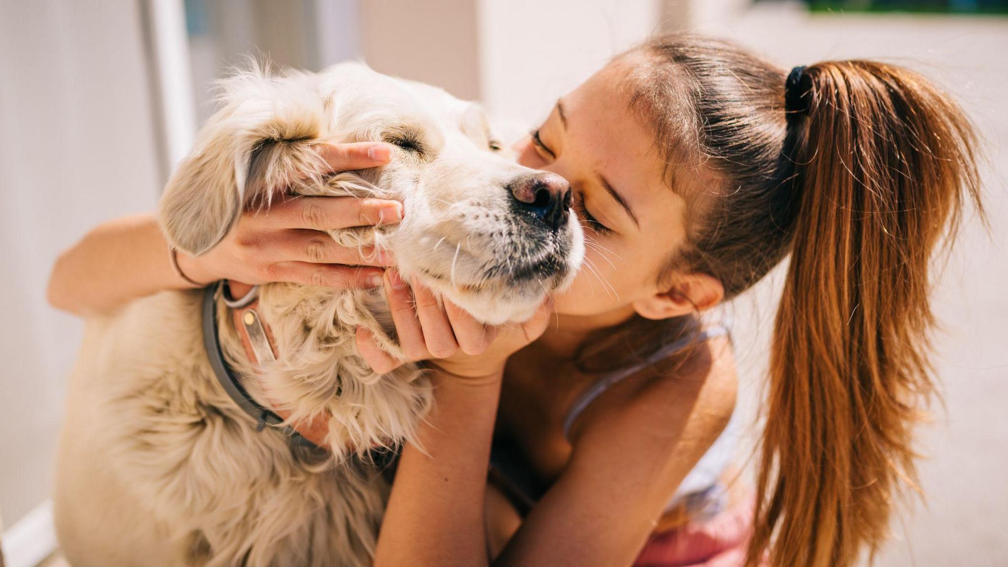 Girl kissing dog. 