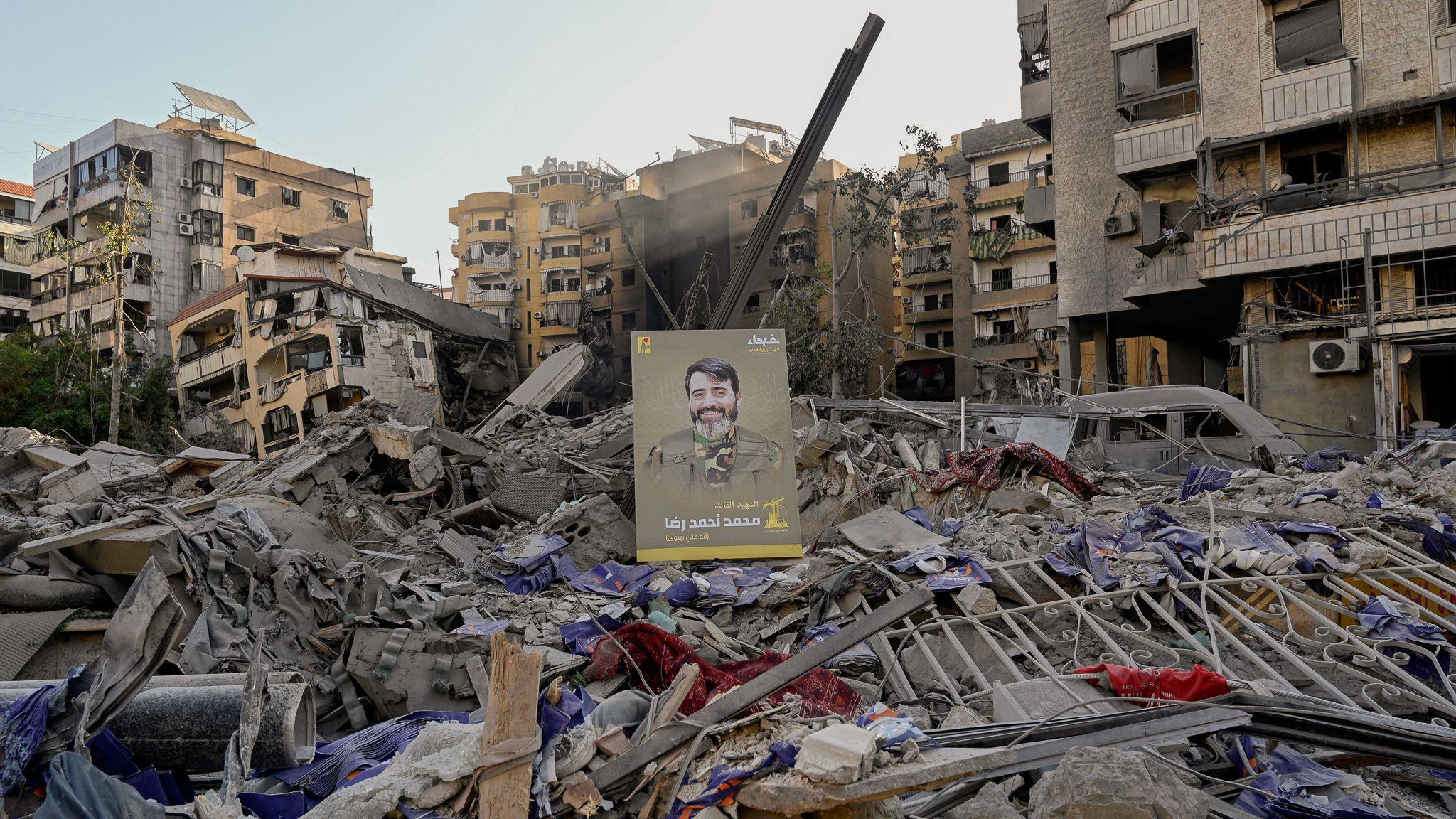 An image of a Hezbollah fighter is displayed on the rubble following an Israeli strike on the suburb.