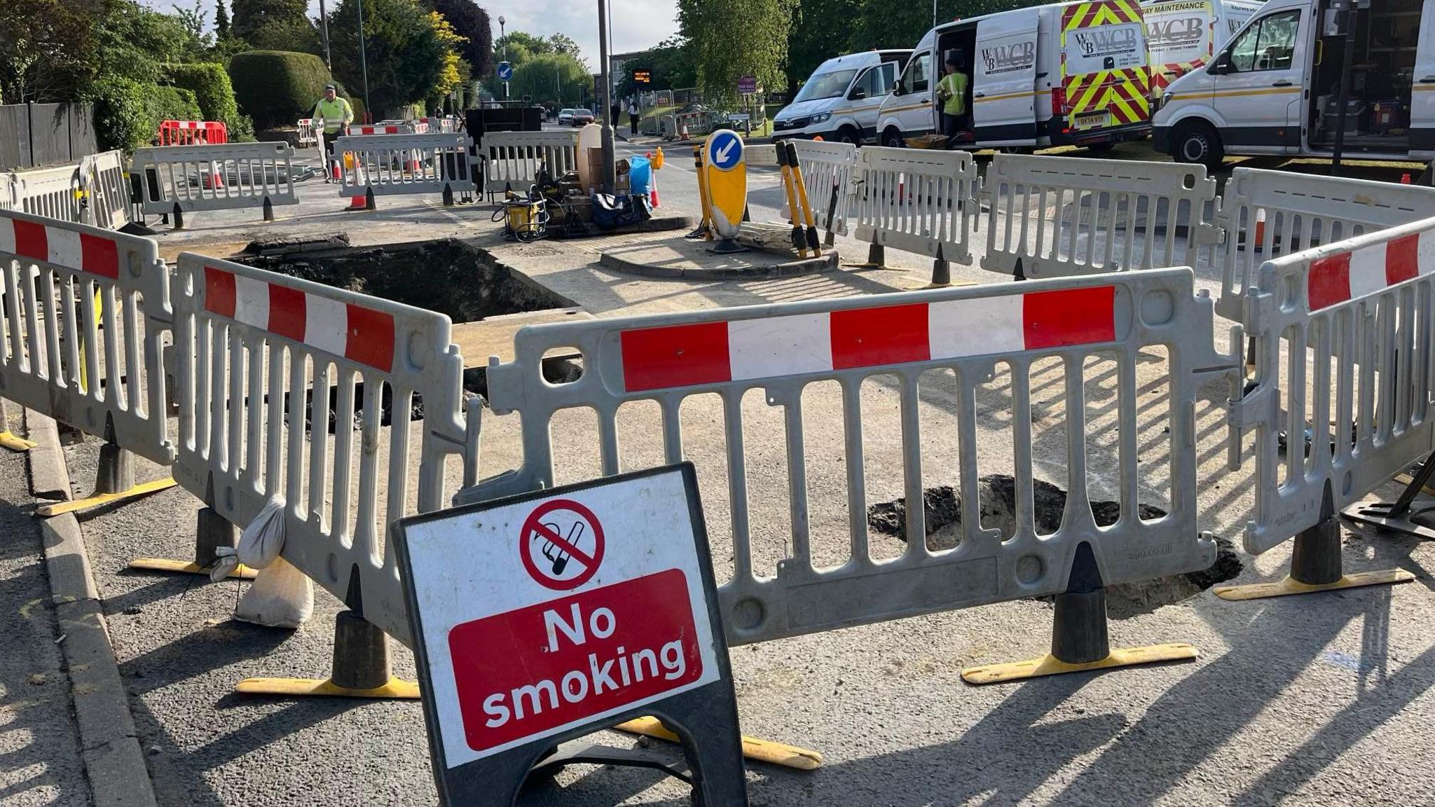 No smoking sign next to gas mains roadworks cordoned off by barriers on Loose Road, Maidstone