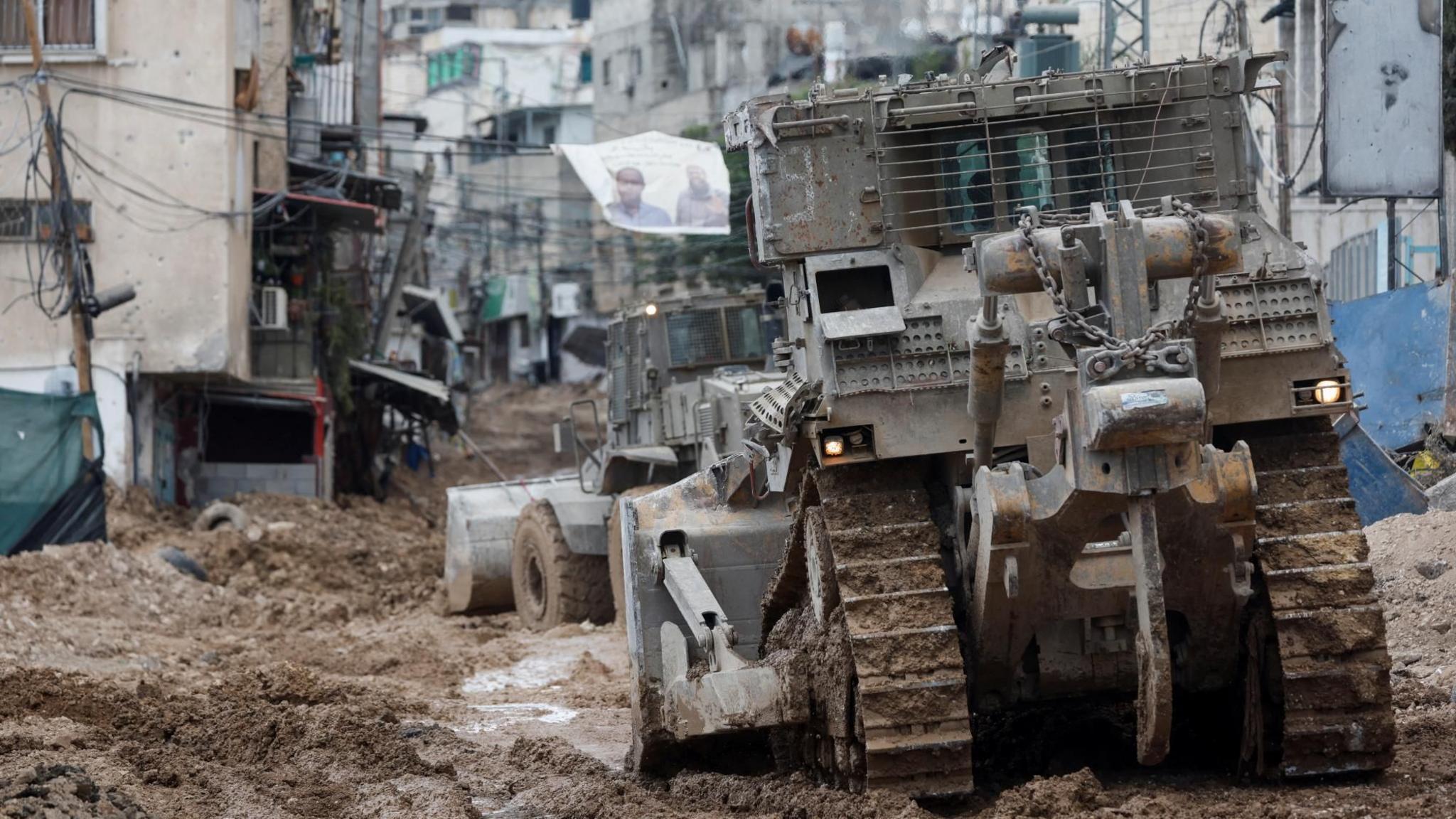 An Israeli armoured bulldozer digs up a road during a raid in Tulkarm, in the occupied West Bank (4 September 2024)