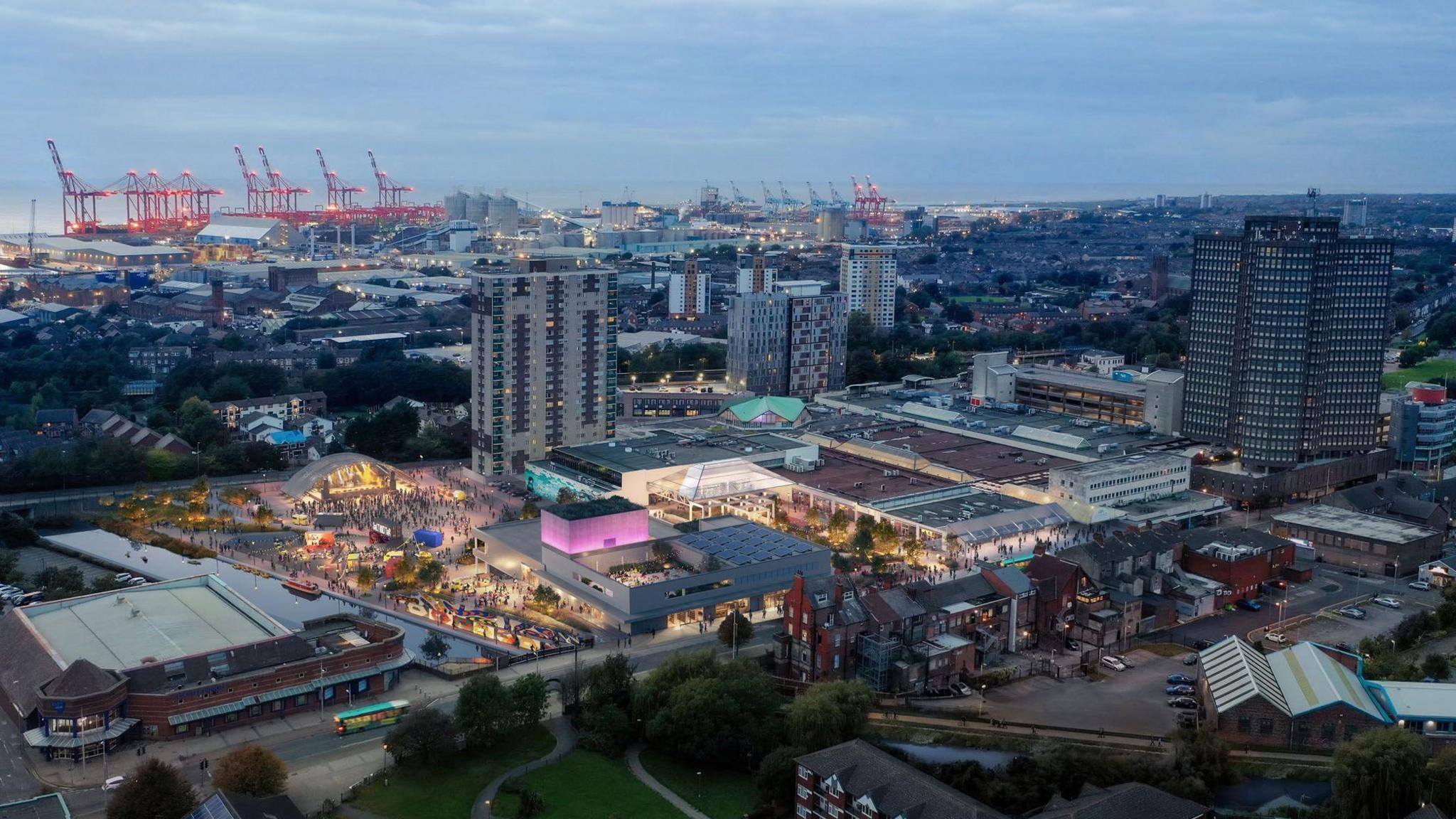 Aerial view of Bootle Strand and Salt & Tar events venue showing an area lit up with docks in the background and port cranes
