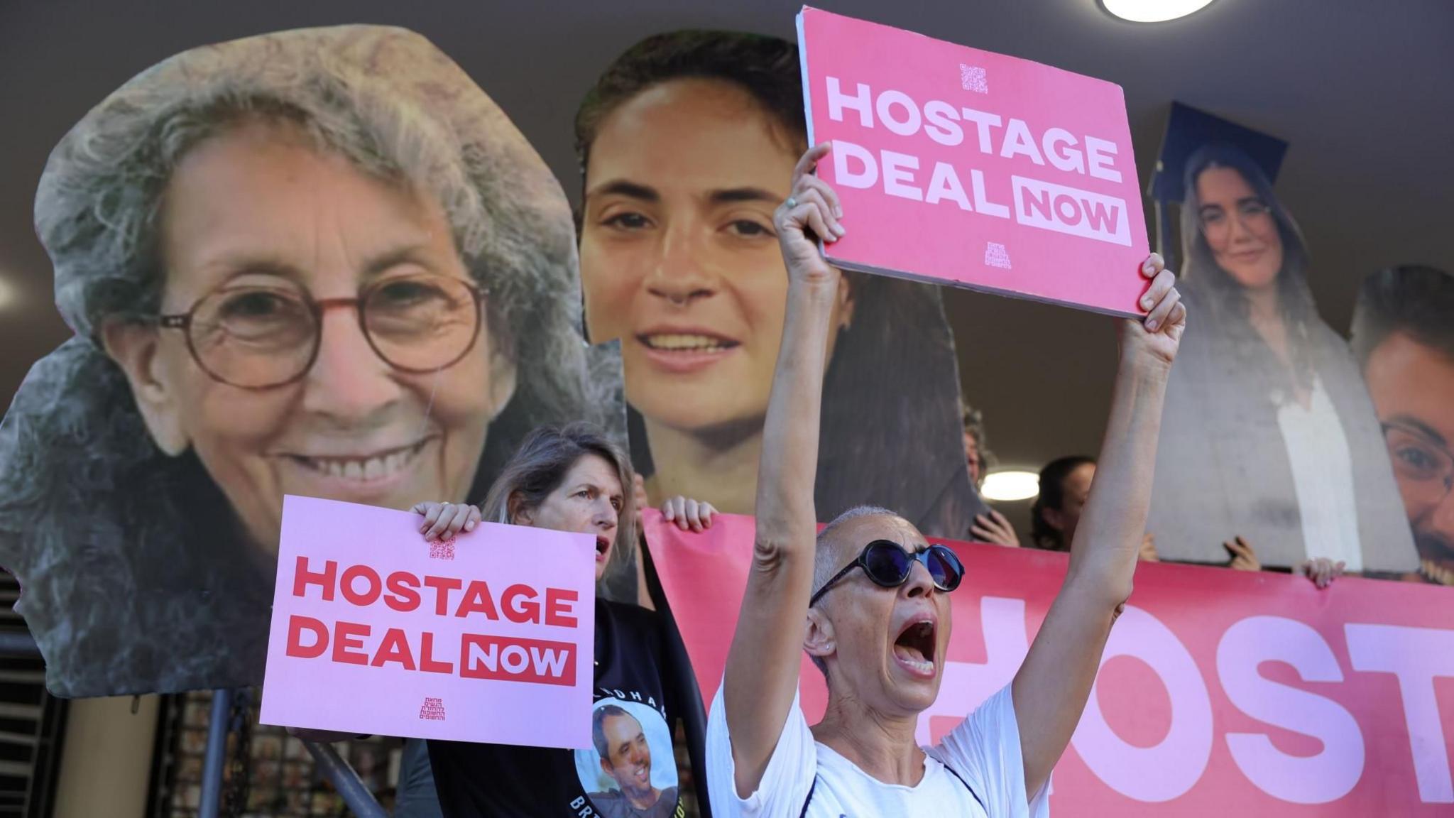 People hold up posters of Israeli hostages in Gaza at a protest calling for release deal at a rally in Tel Aviv, Israel (15 August 2024)
