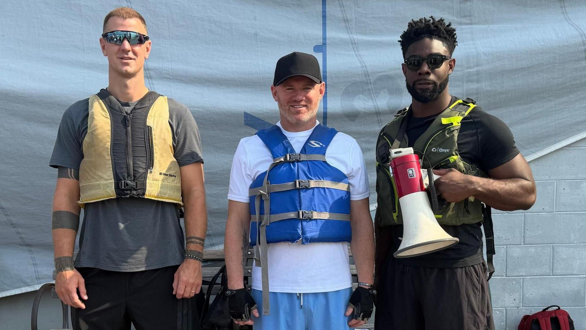 Joe Hart, Wayne Rooney and Micah Richards wearing life jackets