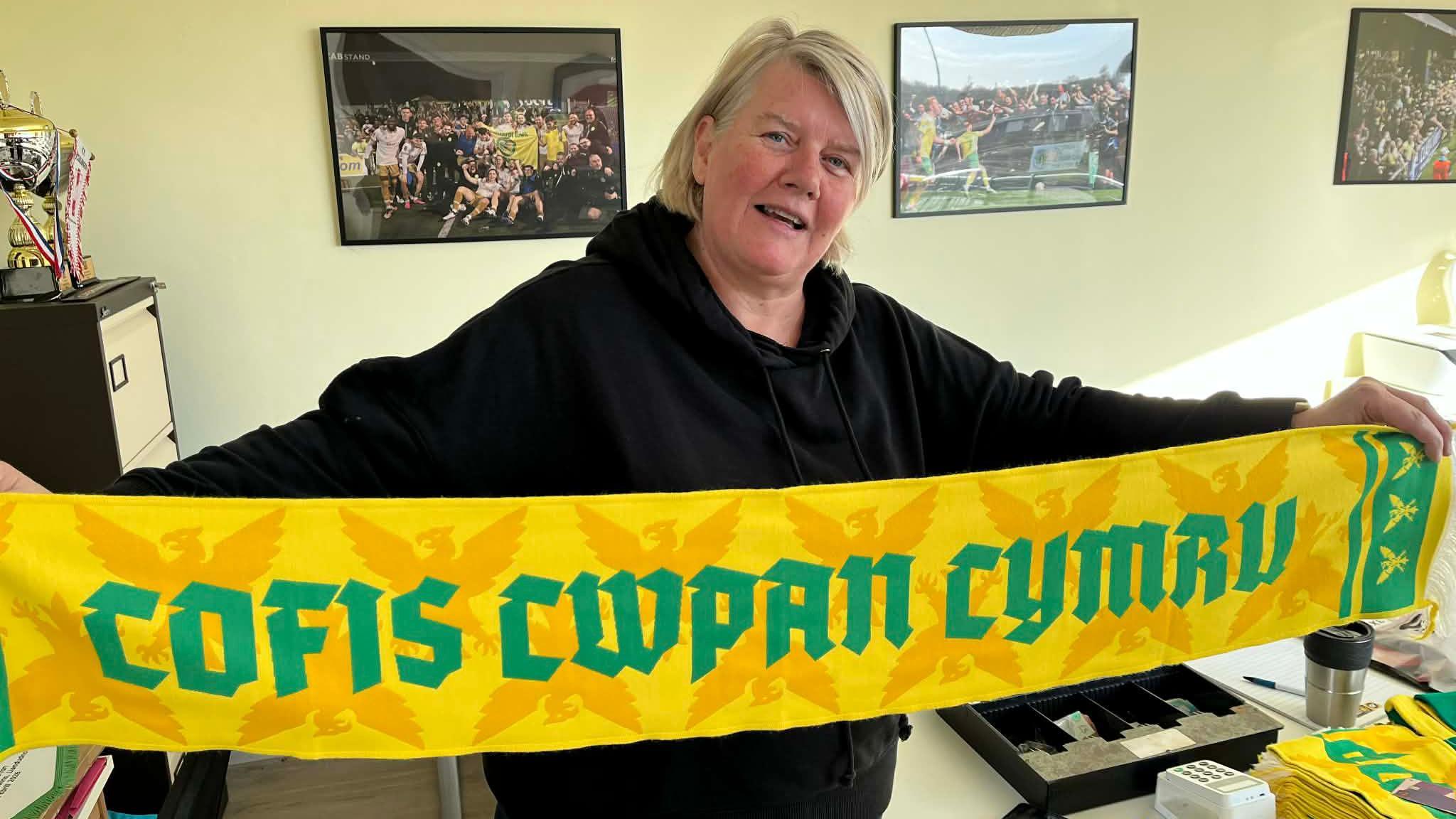 Sandra Ross yn dal sgarff Caernarfon