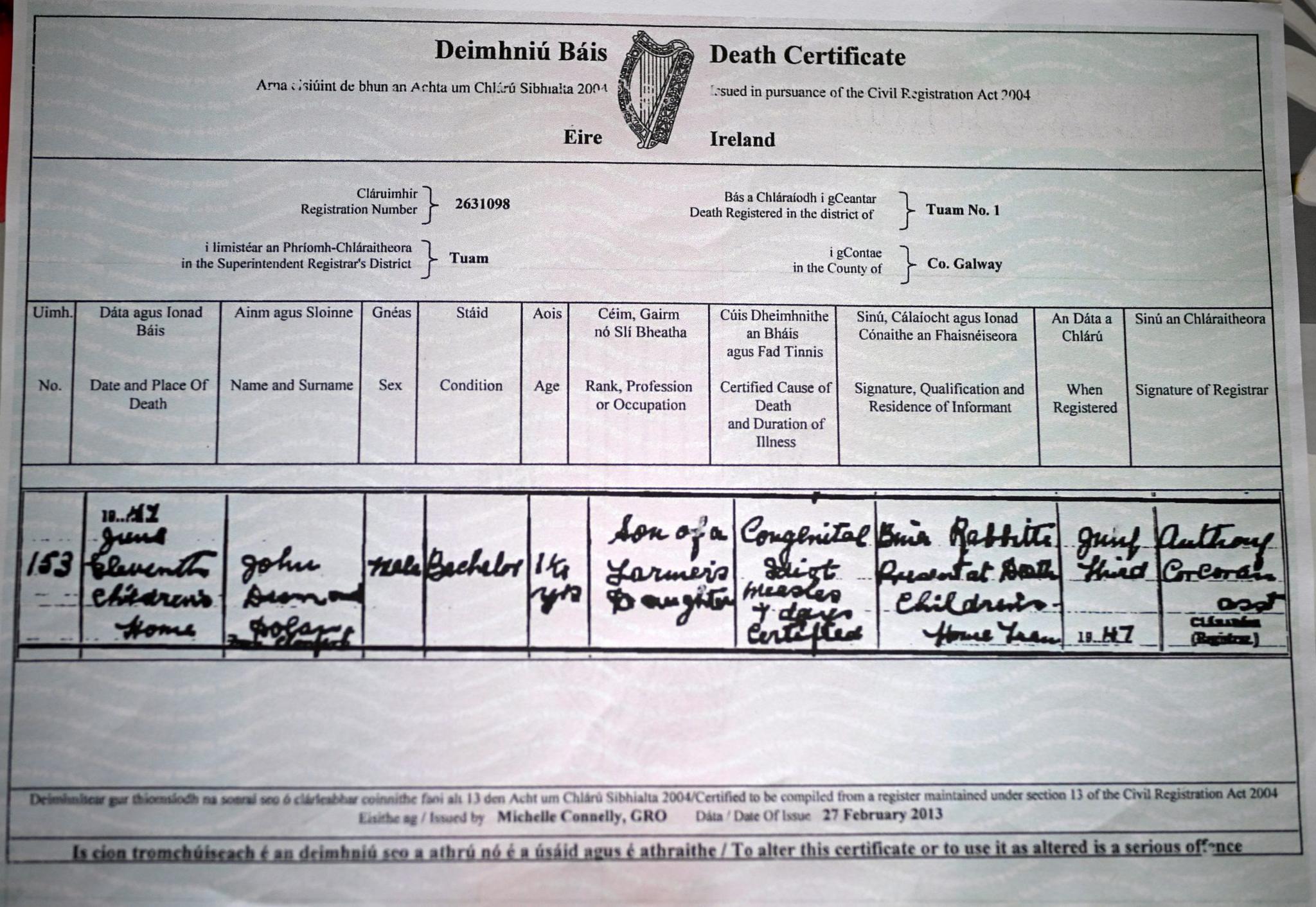 A close-up on an Irish death certificate. It has a table of information including name, date and place of death, sex, age and other details. The information is written in flowing cursive writing and notes that the dead person is called John, was 16 months old and lists "congenital idiot" and "measles" under cause of death